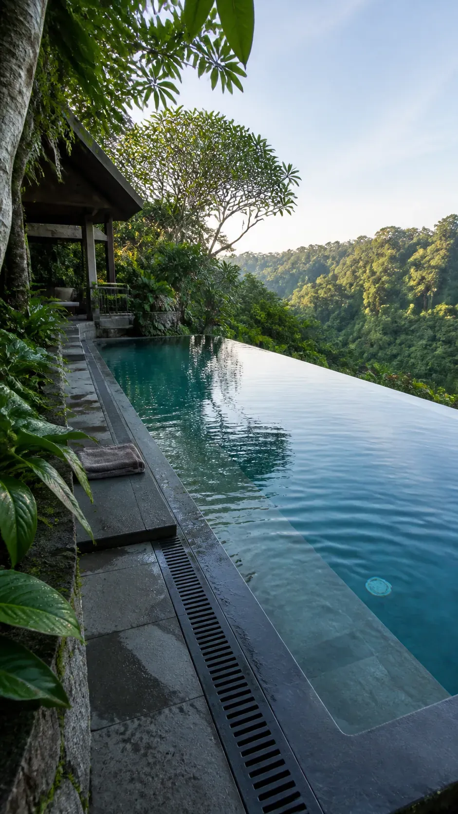 Tropical infinity pool overlooking dense green garden