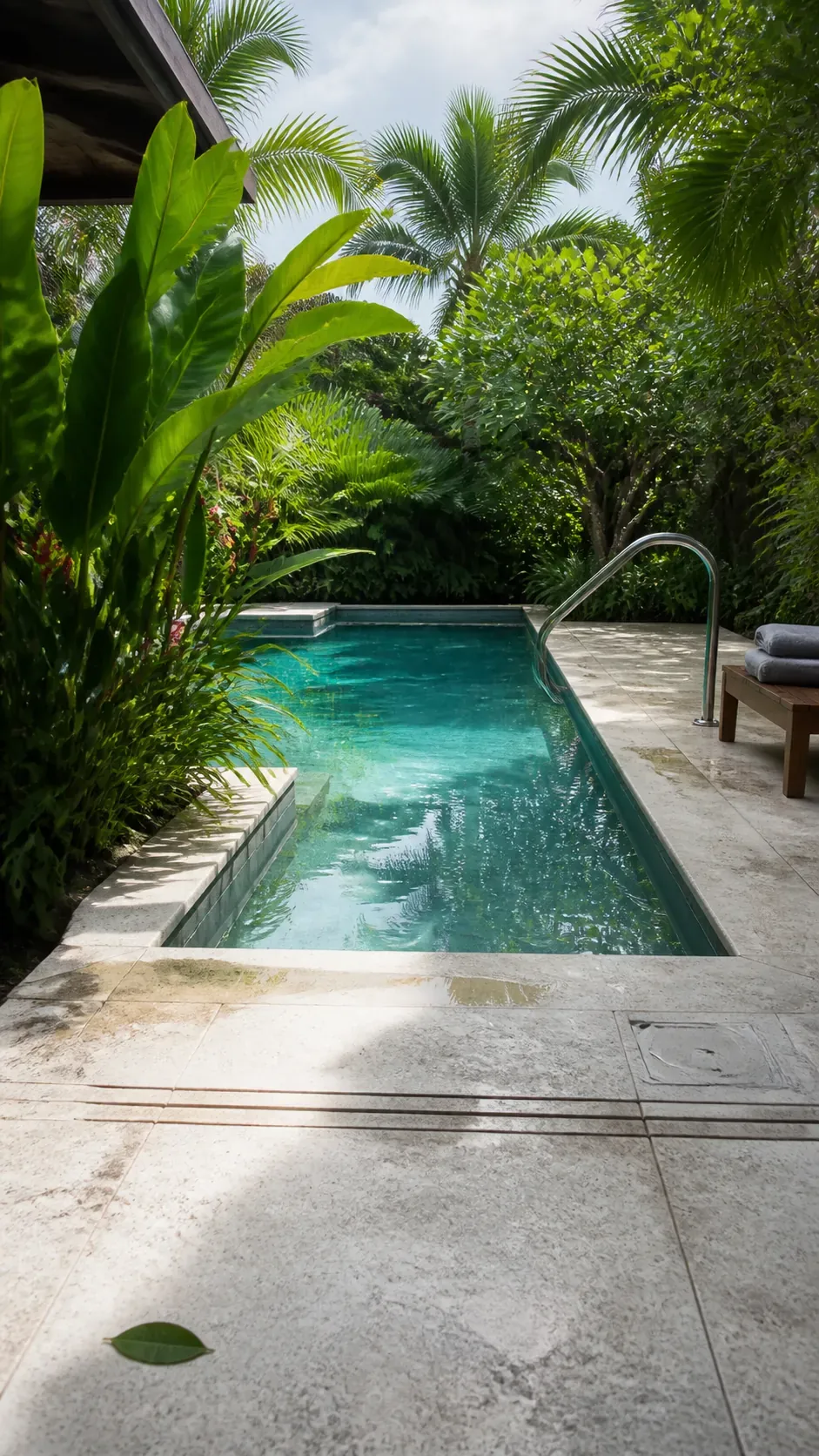 Tropical pool with pale limestone decking and soft green borders