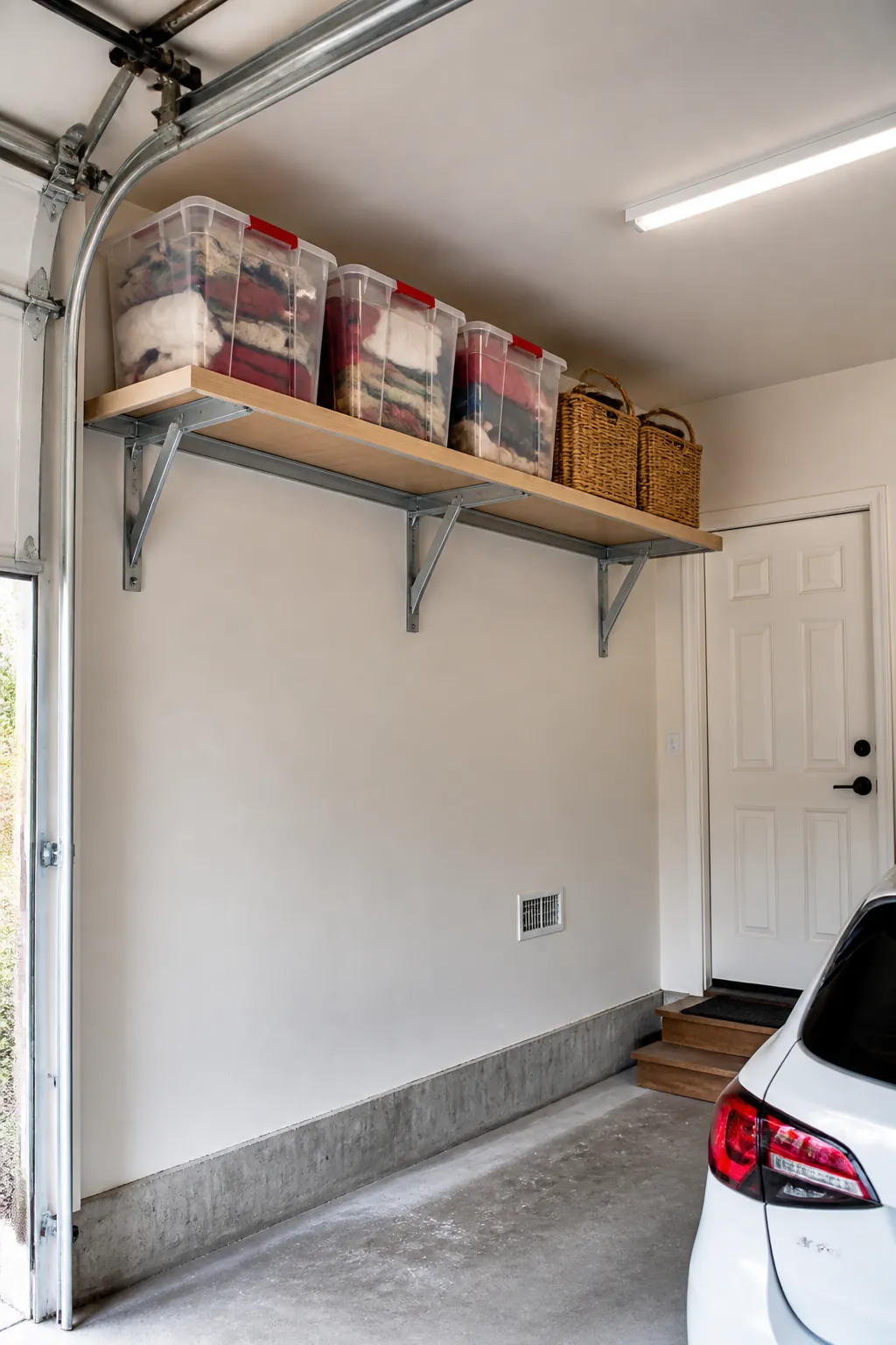 High perimeter shelf storing lightweight seasonal garage bins