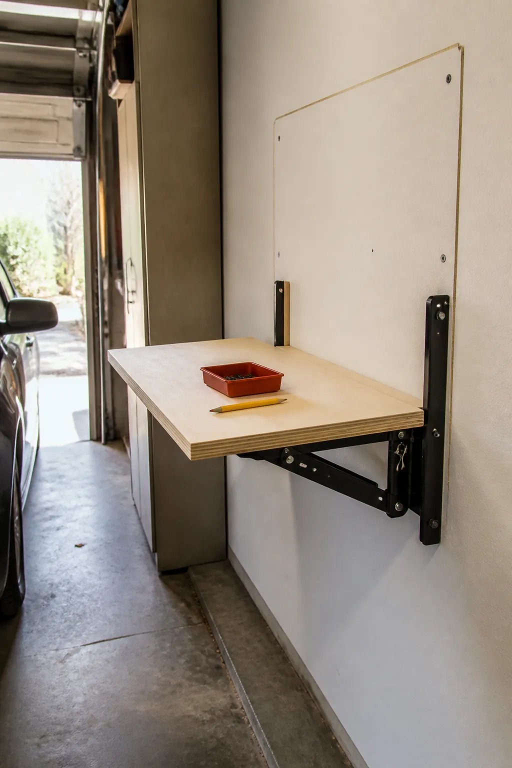 Fold-down task surface opened in a narrow garage work area