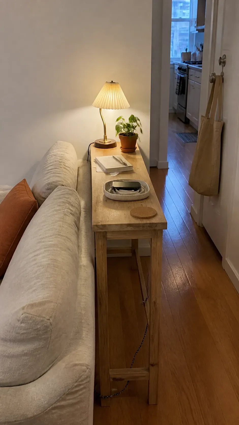 Slim wood console behind a sofa in a small apartment