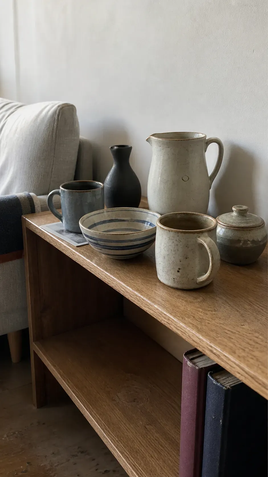 Small curated handmade ceramic collection on one apartment shelf