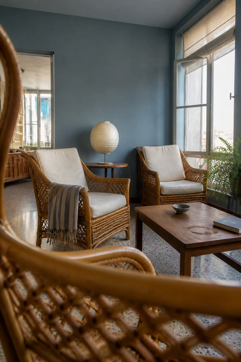 Blue-gray living room walls with warm rattan seating