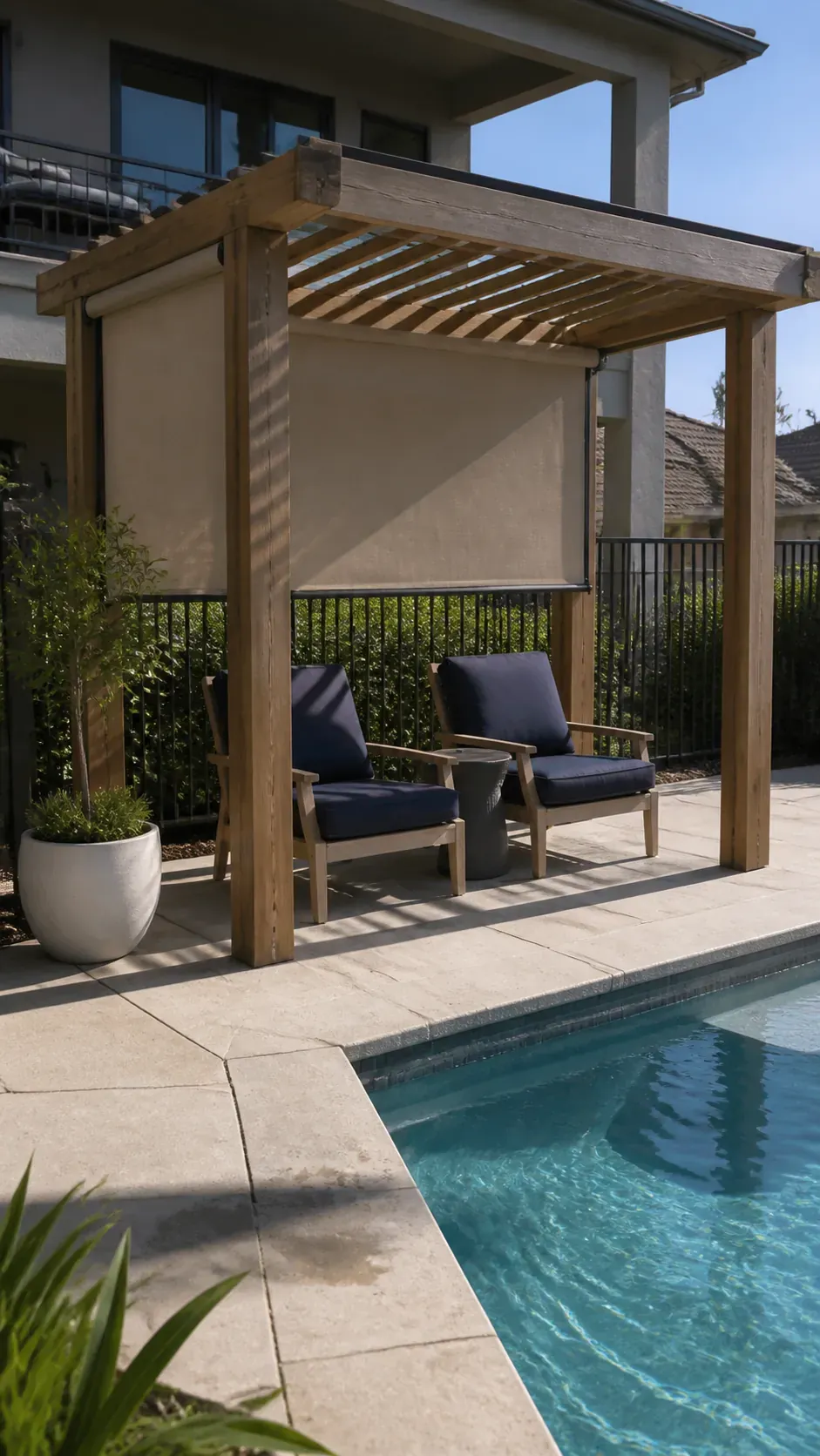 Poolside pergola with a retractable side shade creating lounge privacy