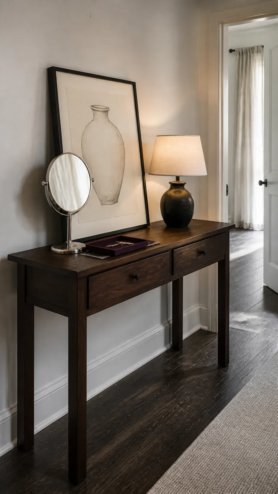 leaning charcoal art and petite mirror console decor
