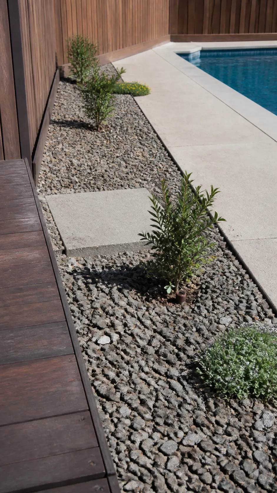 Affordable gravel landscaping replacing a narrow lawn strip beside a pool