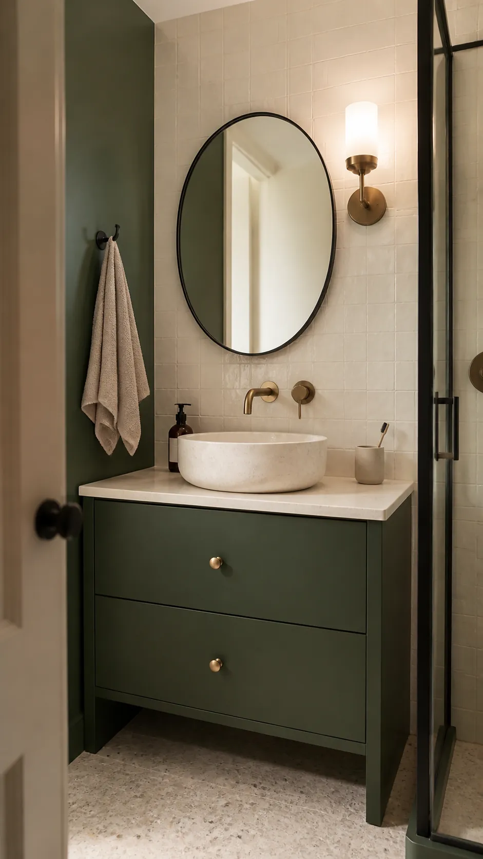 Forest green bathroom with black fixtures, aged brass details, and cream tile