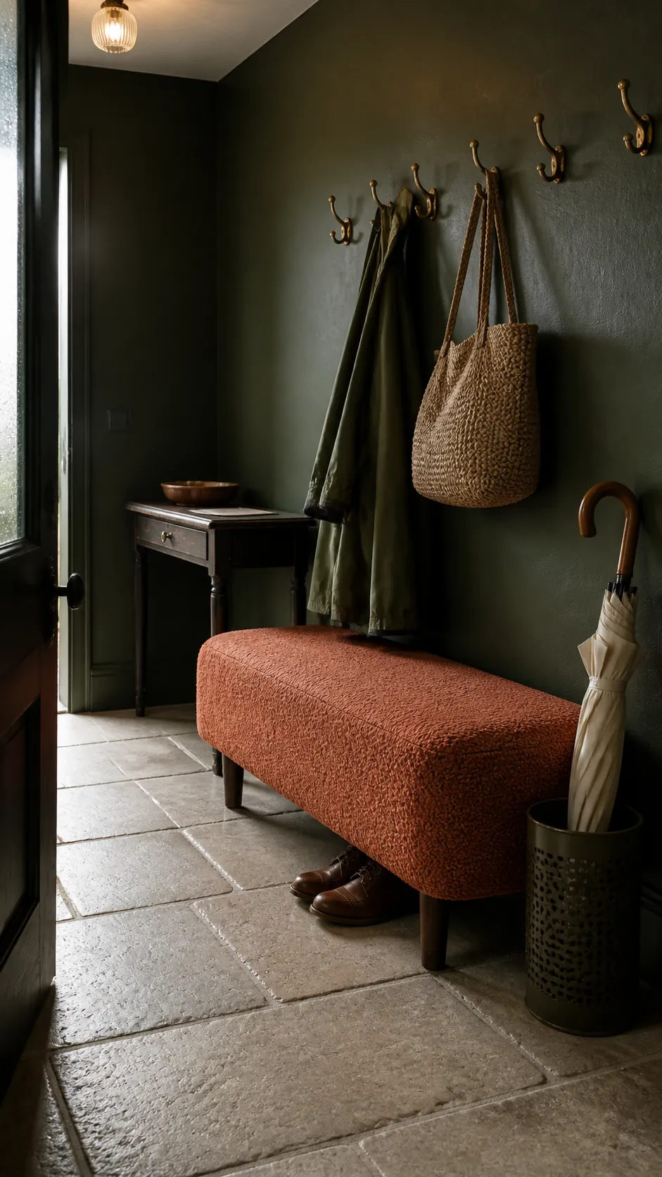 Dark green entryway accented with terracotta upholstery and aged brass