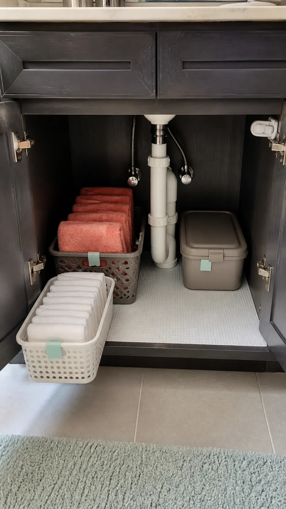 Breathable baskets separating washcloths and hand towels under a sink