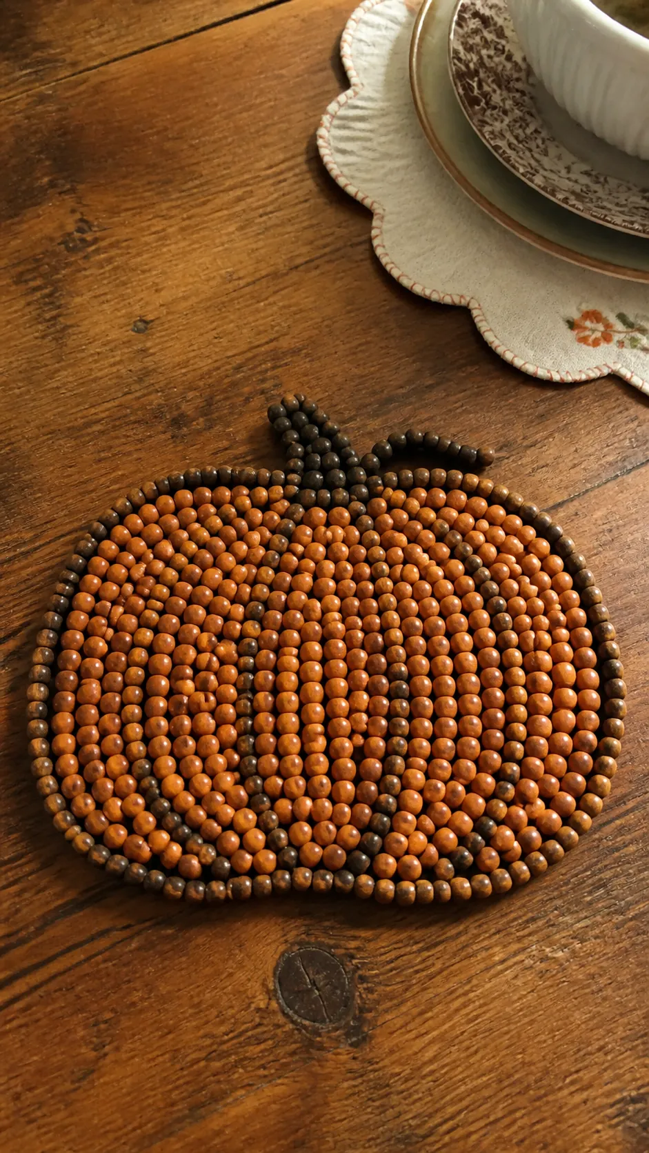 Wood bead pumpkin trivet on a vintage Halloween kitchen table