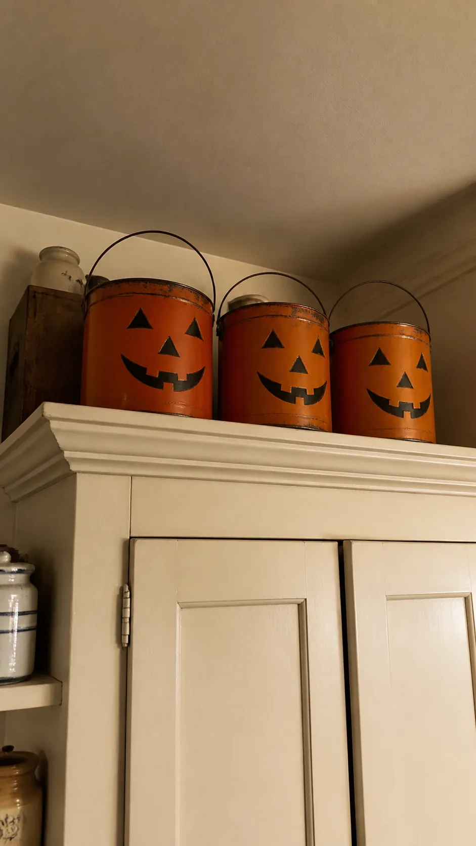 Tin jack o lantern parade above vintage kitchen cabinets