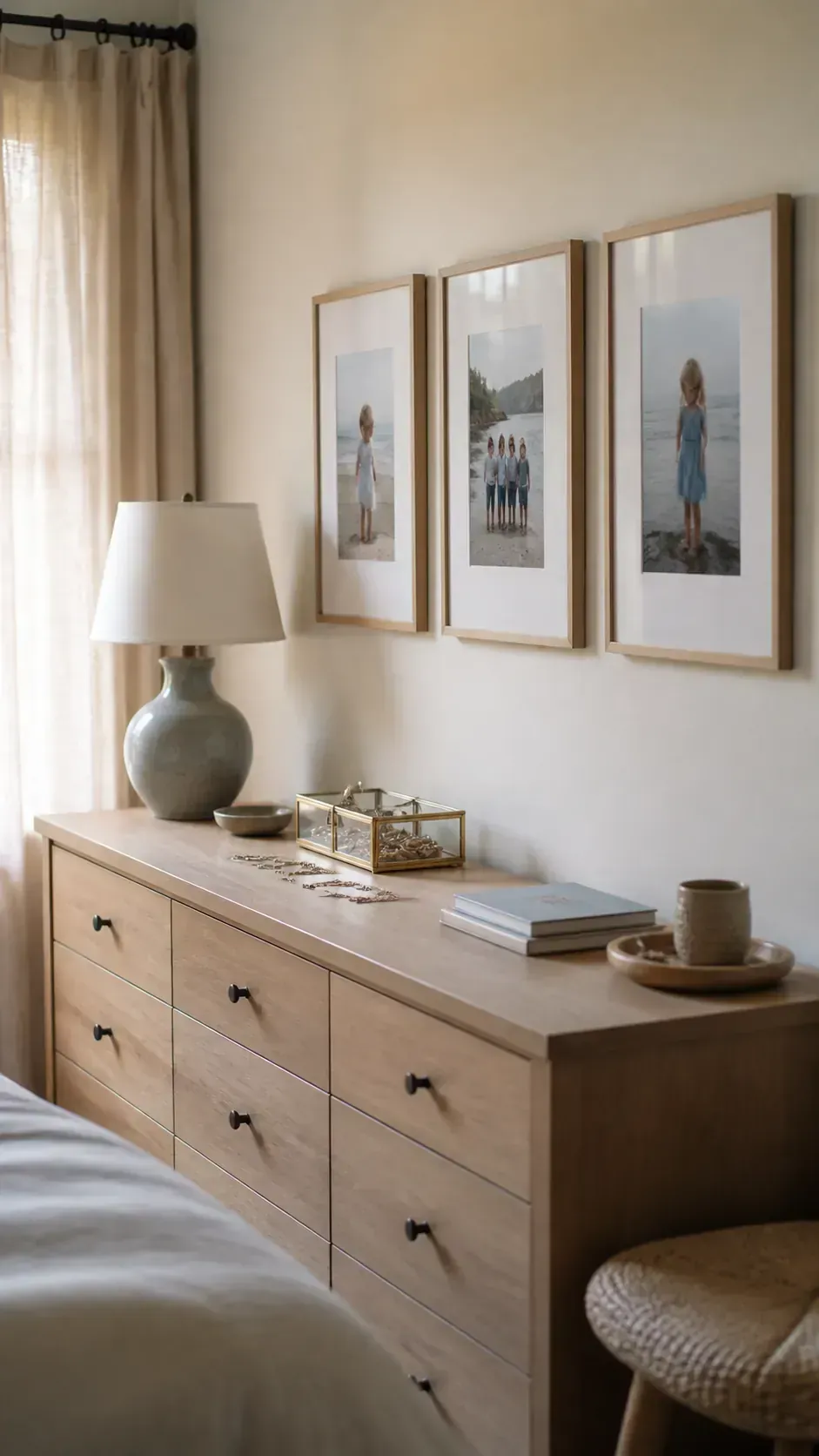 Three large family photo frames above a bedroom dresser