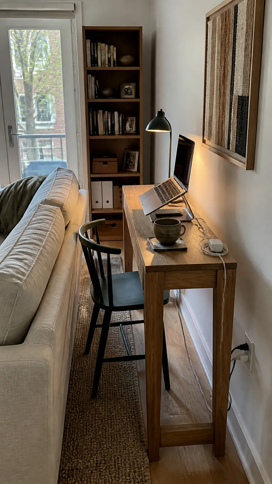 Narrow console desk arranged behind a small apartment sofa