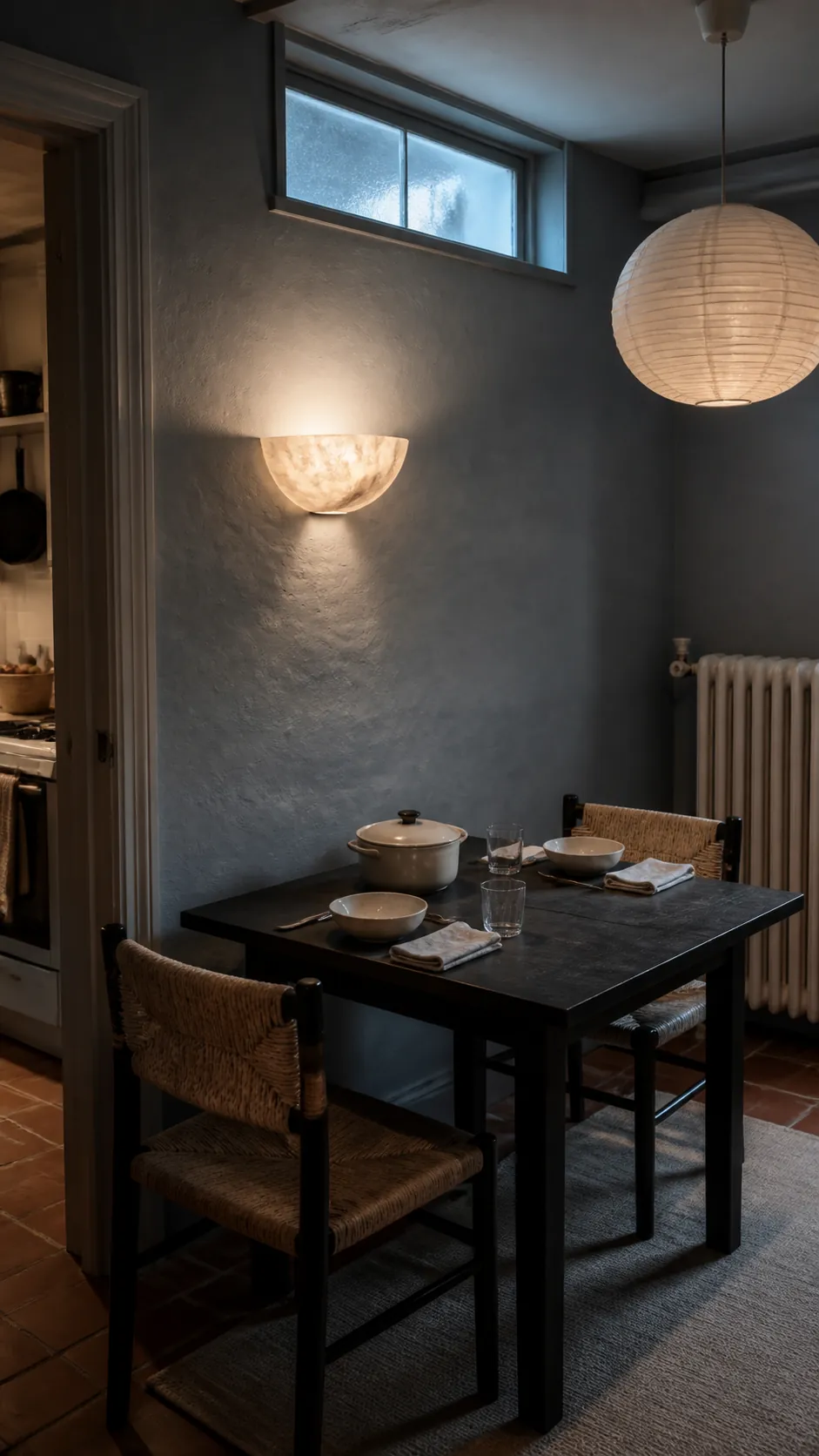 Textured dining wall with a compact sculptural sconce
