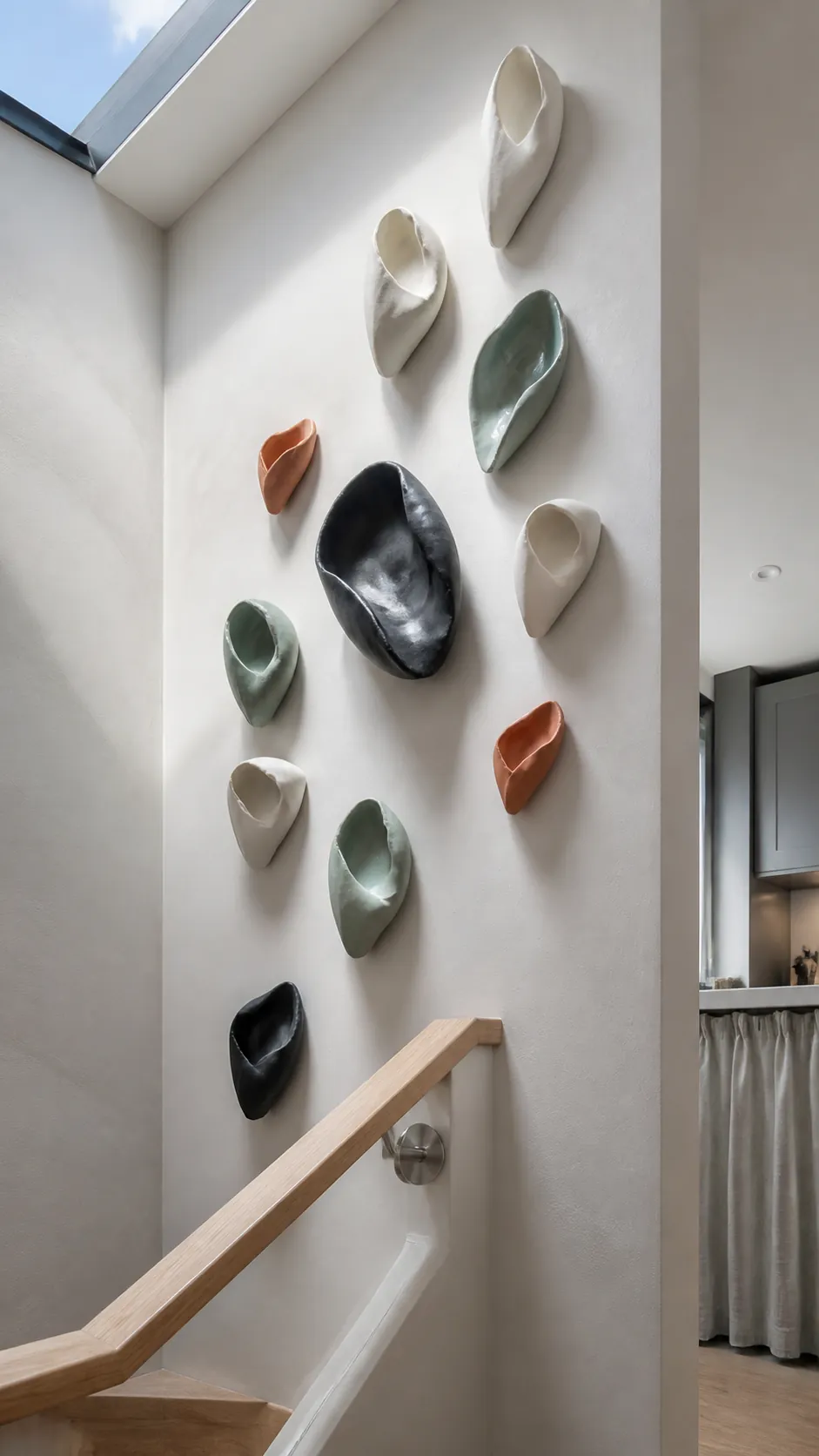 Handmade ceramic folded forms arranged as kitchen wall sculpture