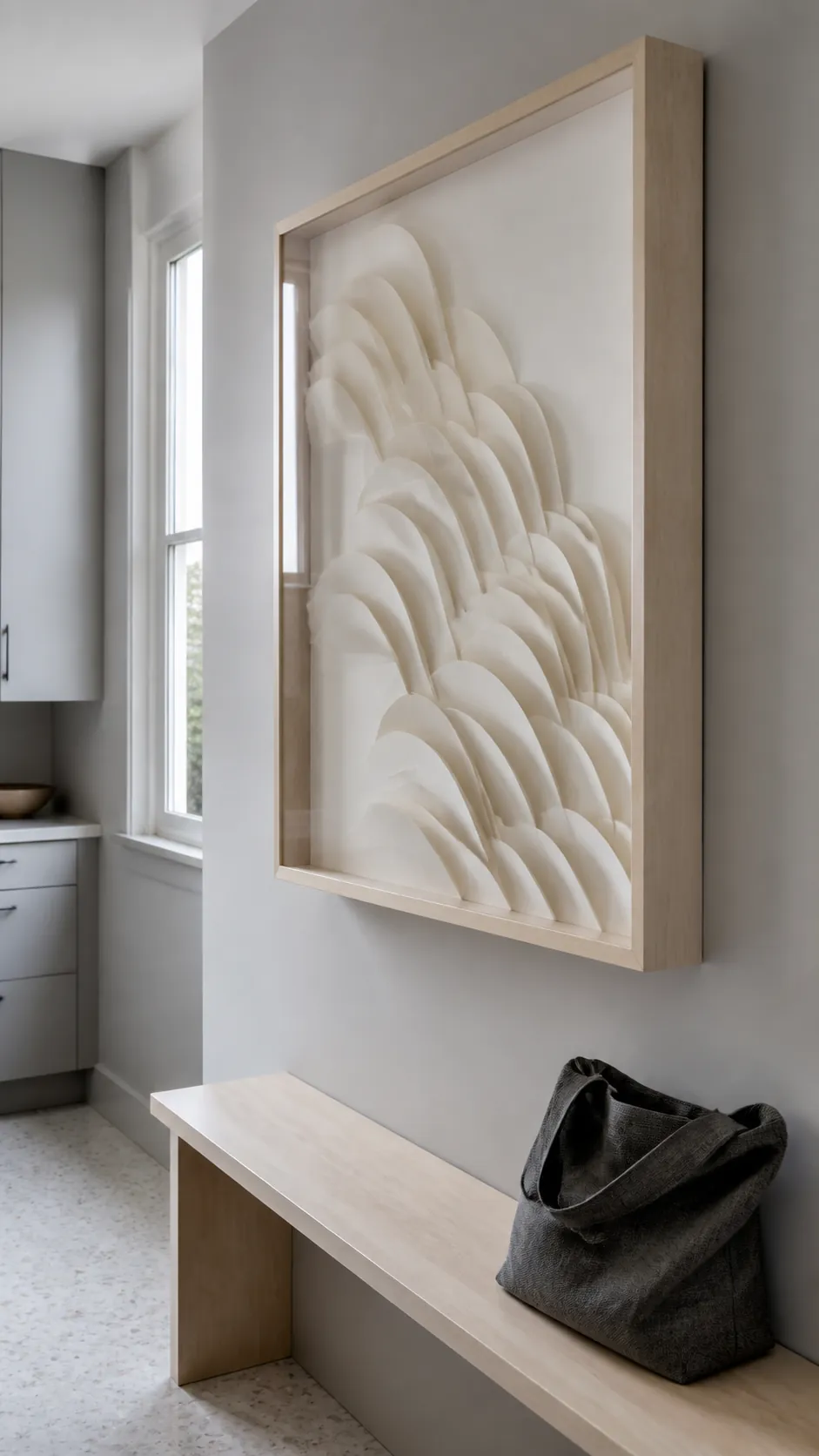 Framed cream paper relief artwork on a quiet kitchen wall