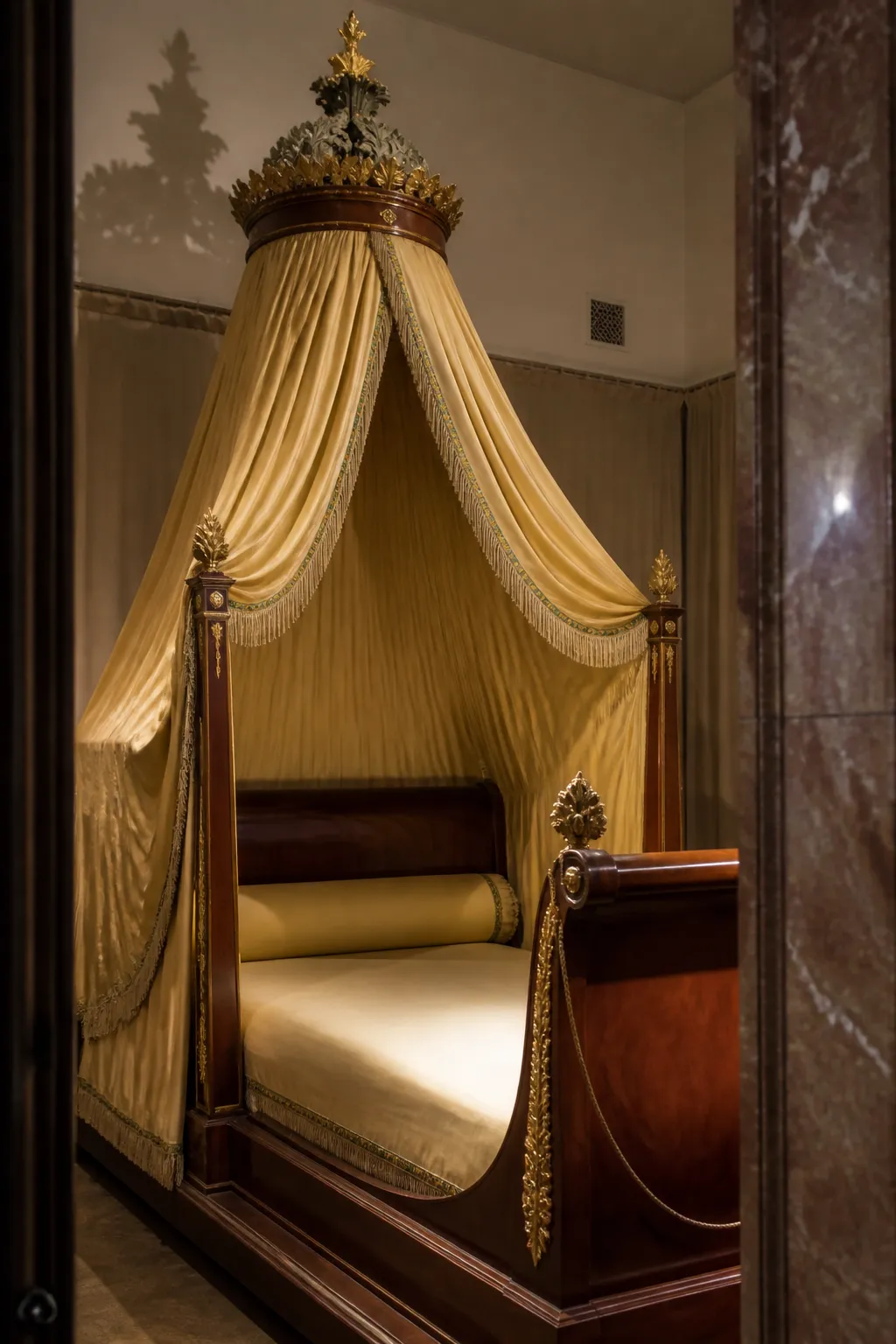 Regal carved bed framed by luminous golden-yellow canopy drapes