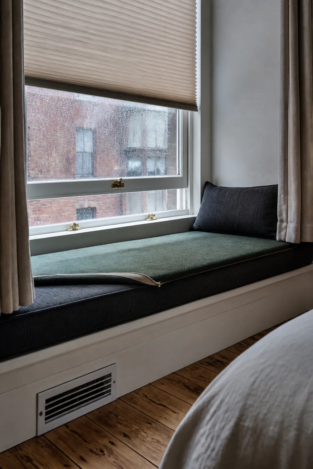 Bedroom window nook with lined shade, clear latch, and layered comfort for cool glass