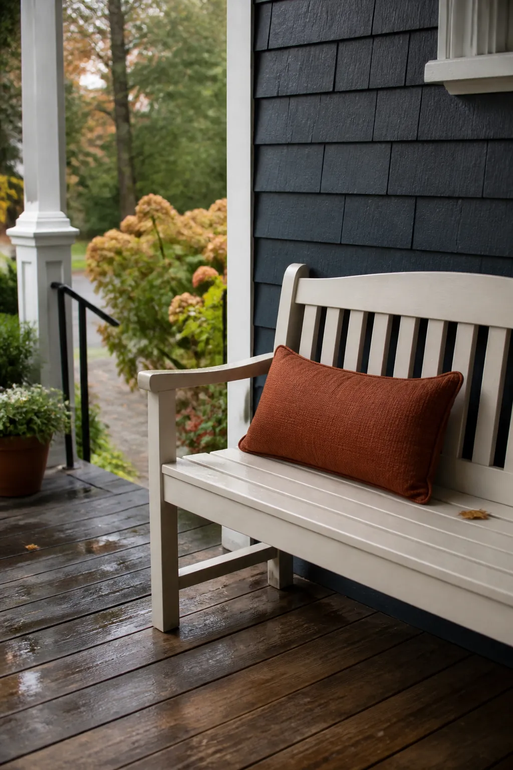 Porch bench styled with one rust colored lumbar pillow