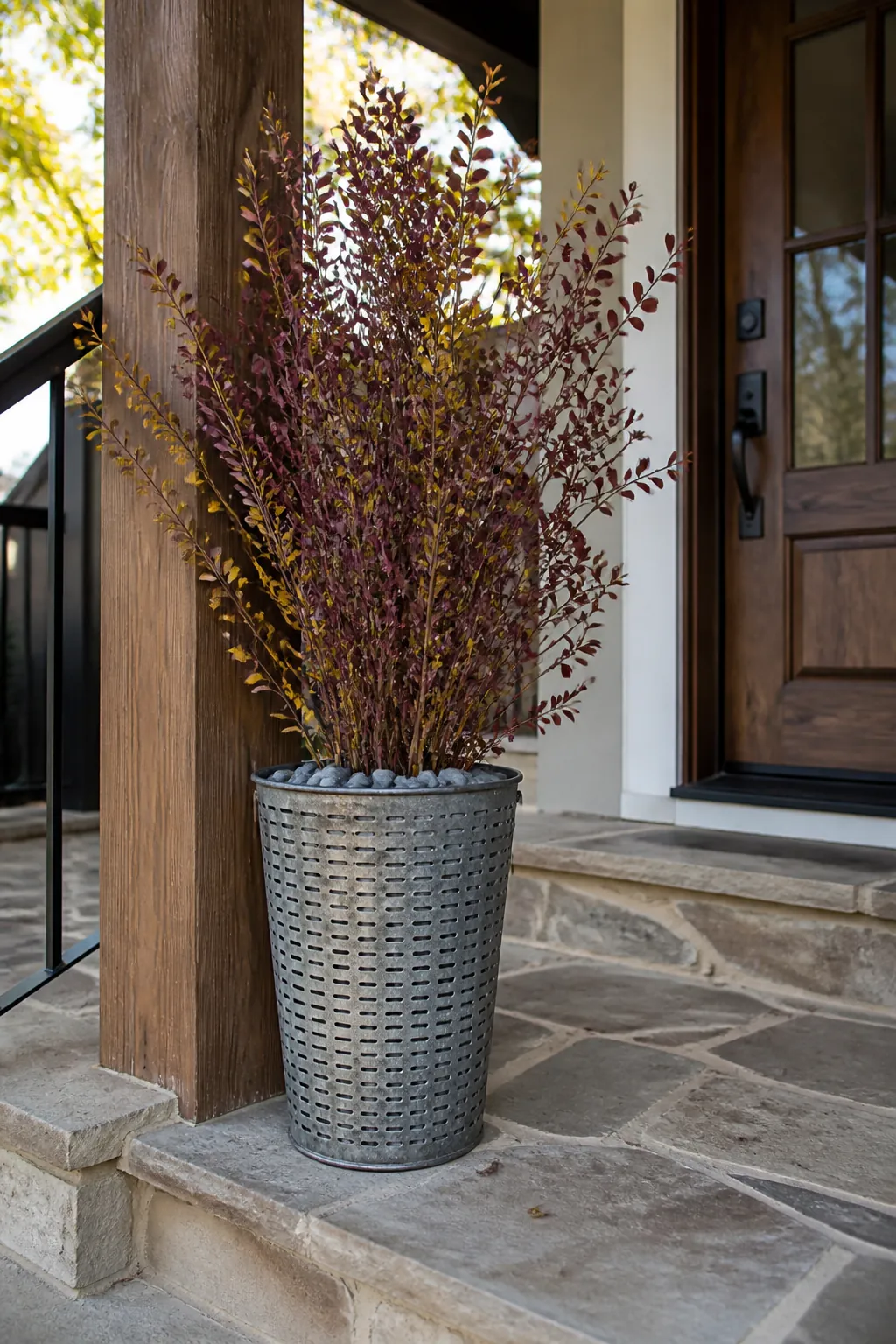 Galvanized olive bucket holding tall autumn branches