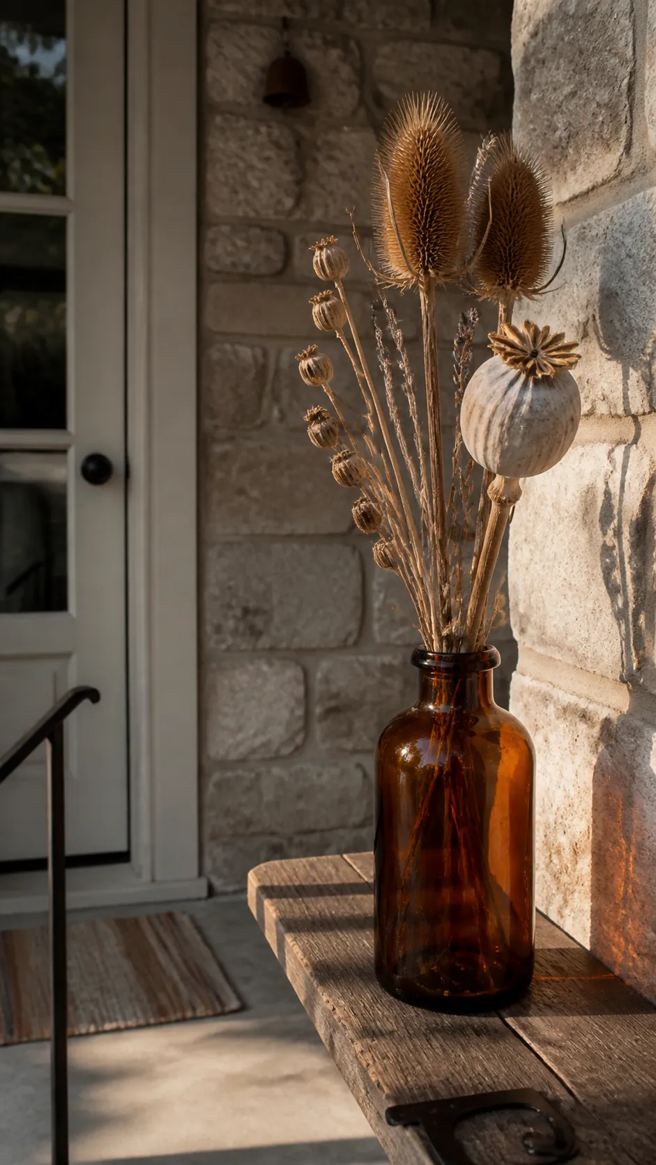 Dried seed heads displayed in a heavy porch bottle