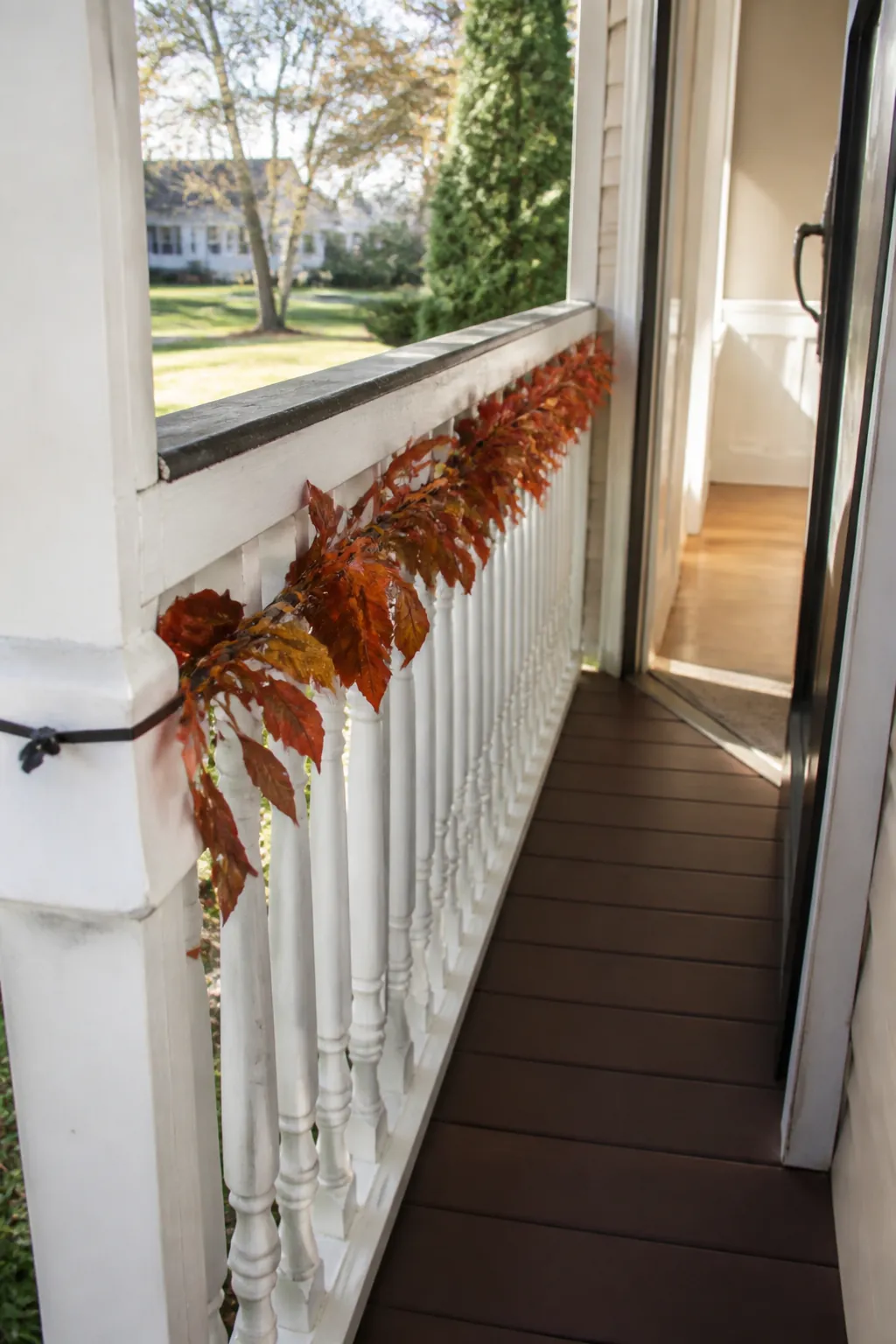 Leafy autumn garland woven along the outside of a small porch rail