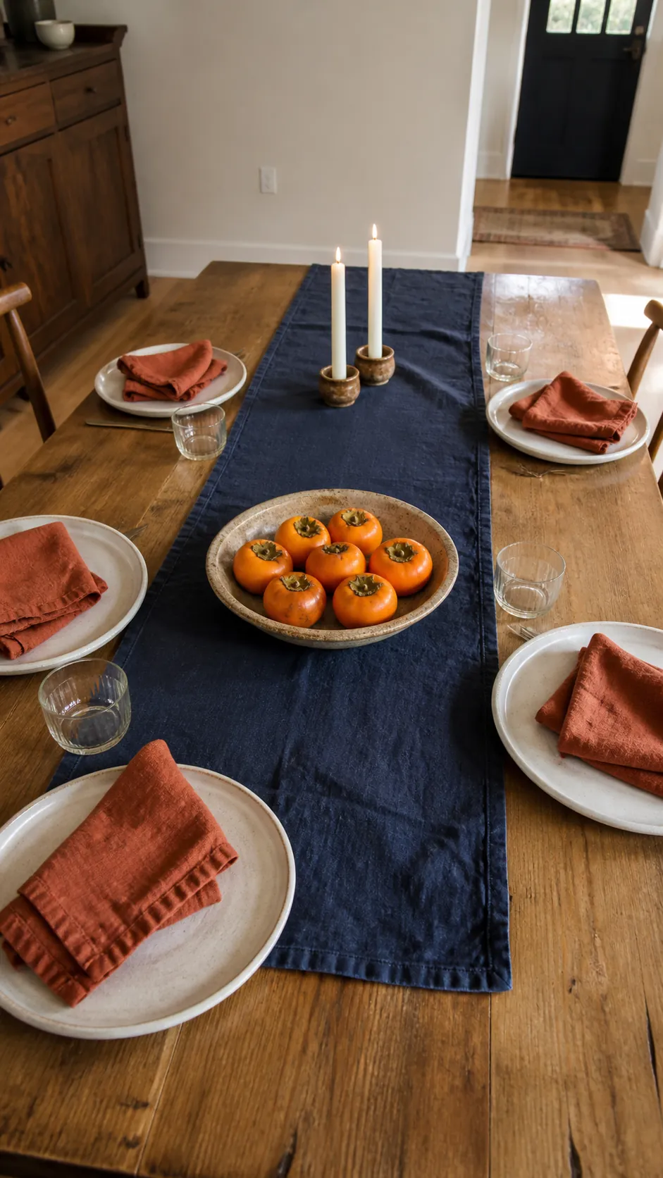 Indigo table runner with persimmons and rust napkins for autumn