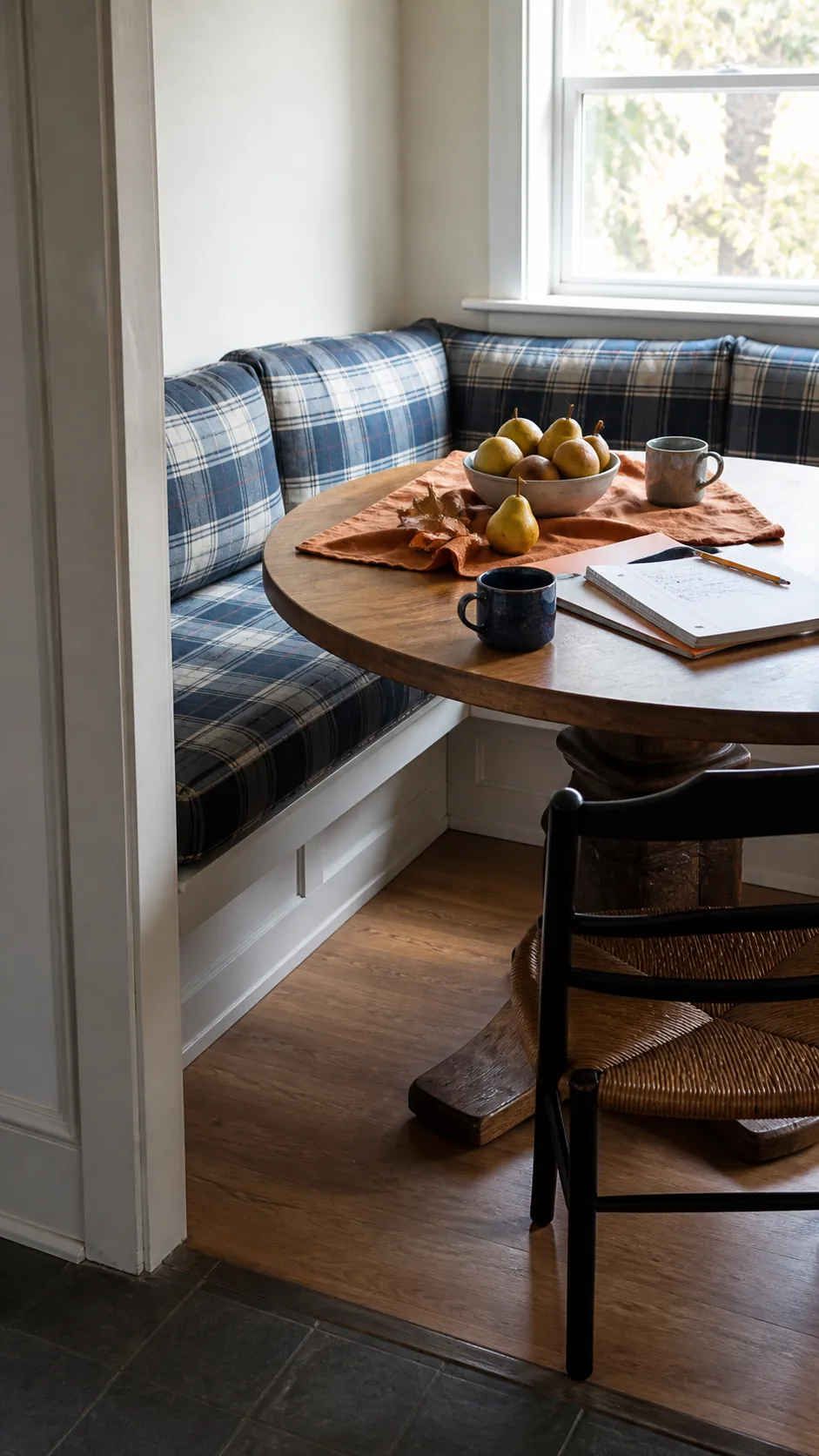 Blue plaid breakfast nook with orange linen and fall fruit