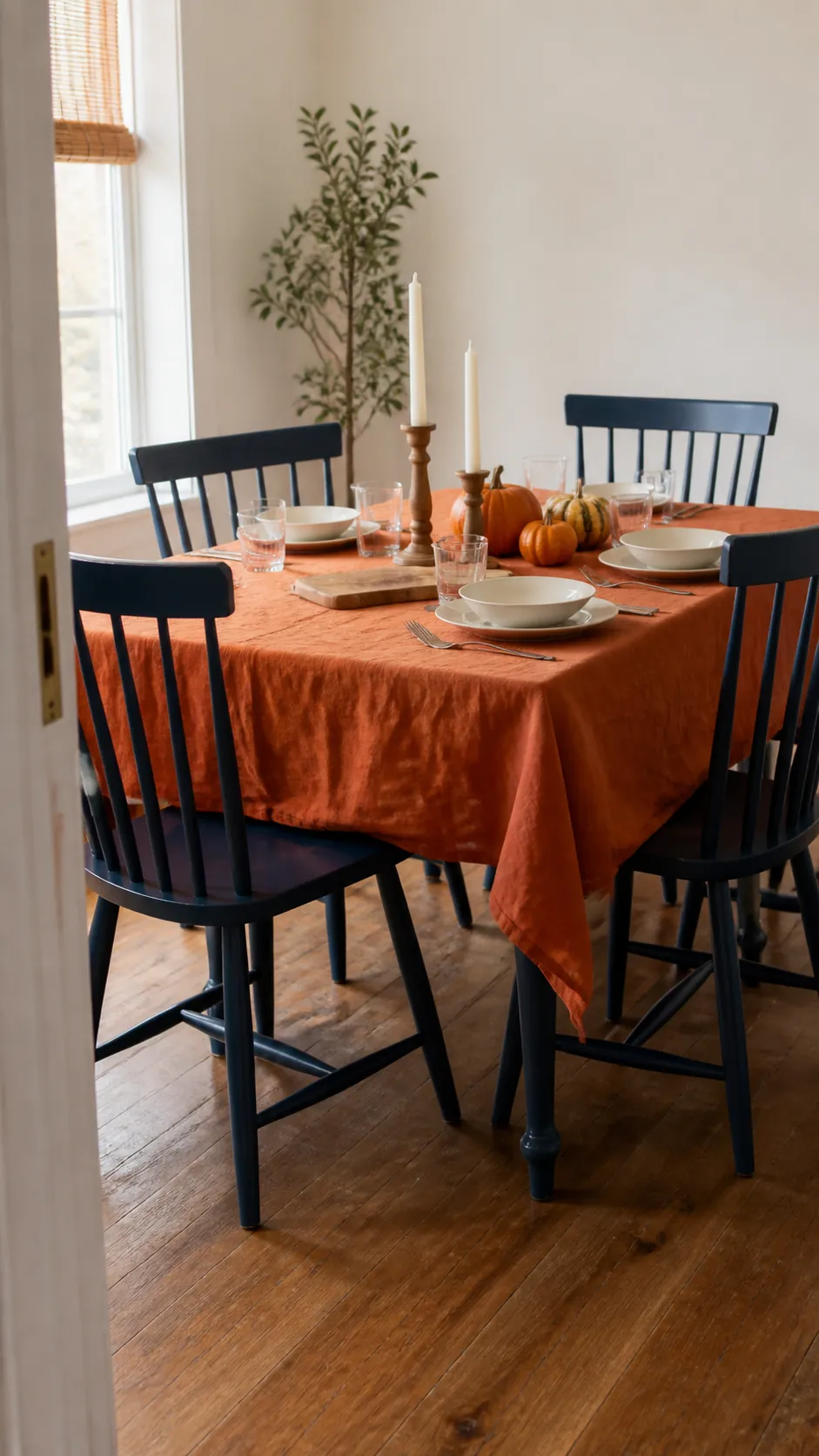 Navy dining chairs surrounding a table with pumpkin orange linen