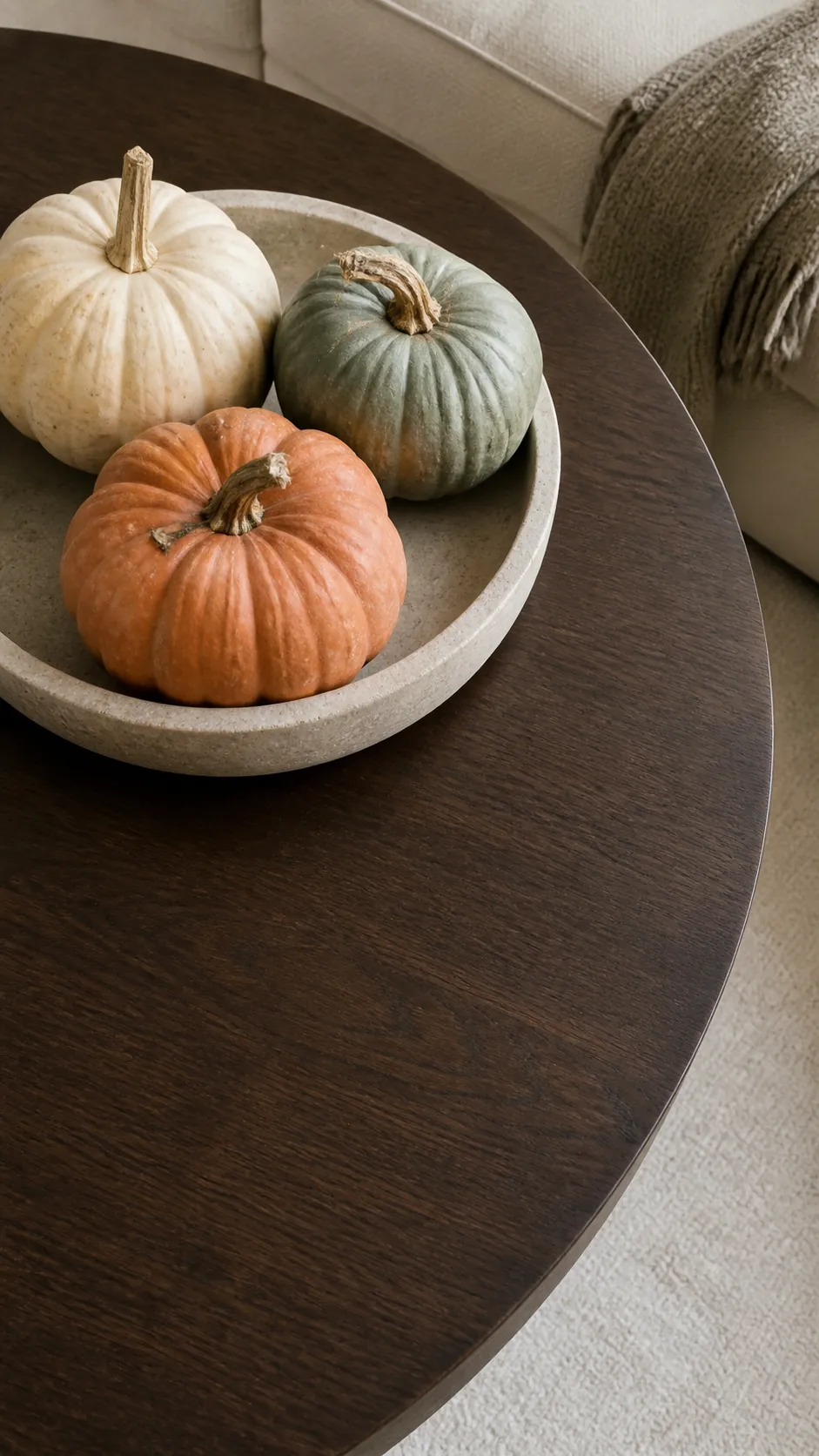 Cream sage and clay pumpkins arranged on a stone dish