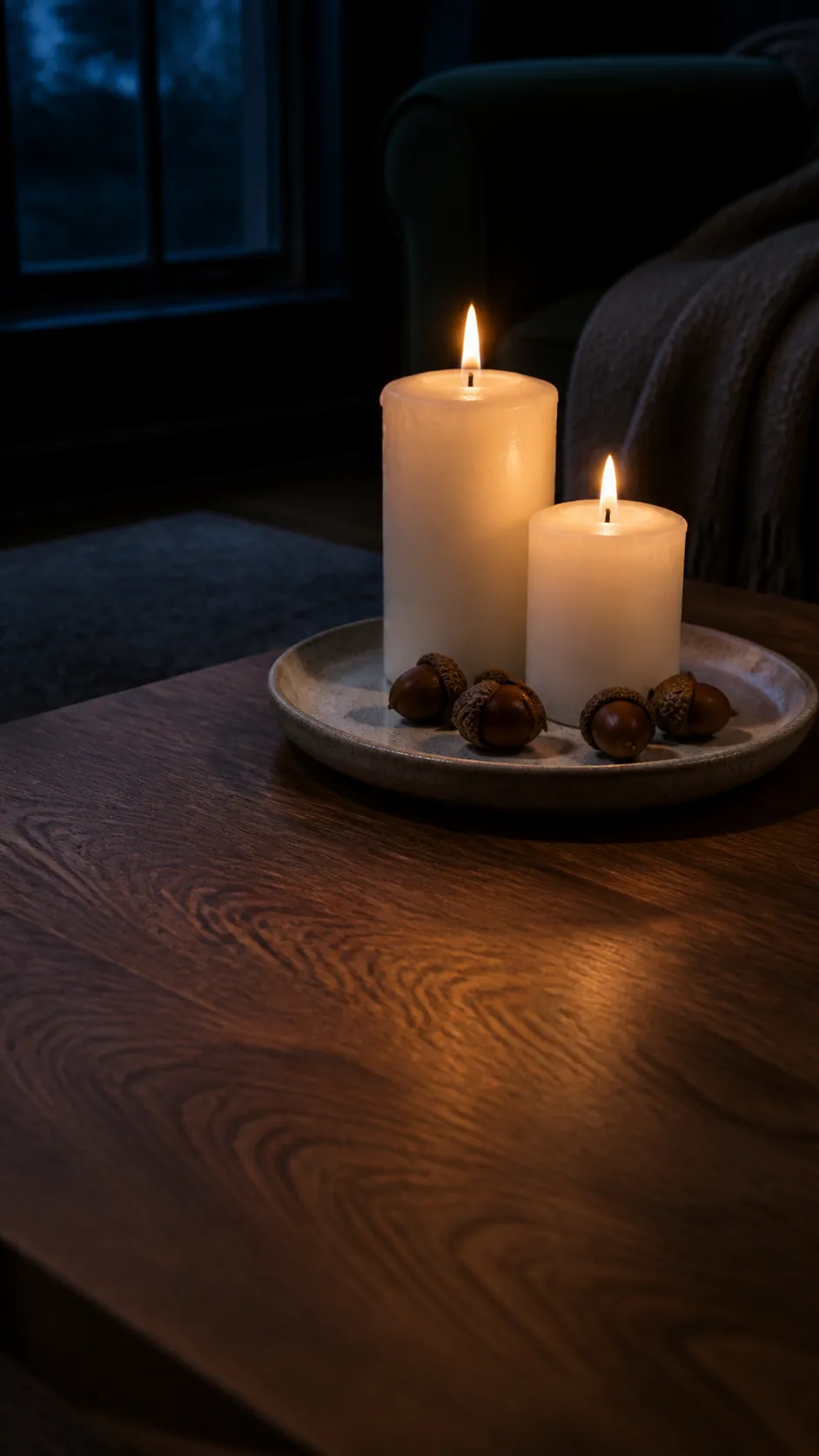 Pillar candles and acorns on a walnut coffee table