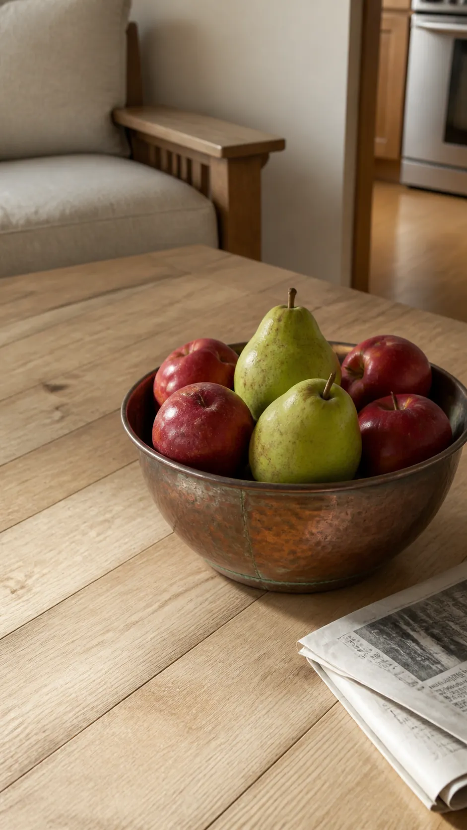 Copper bowl filled with pears and apples on a coffee table