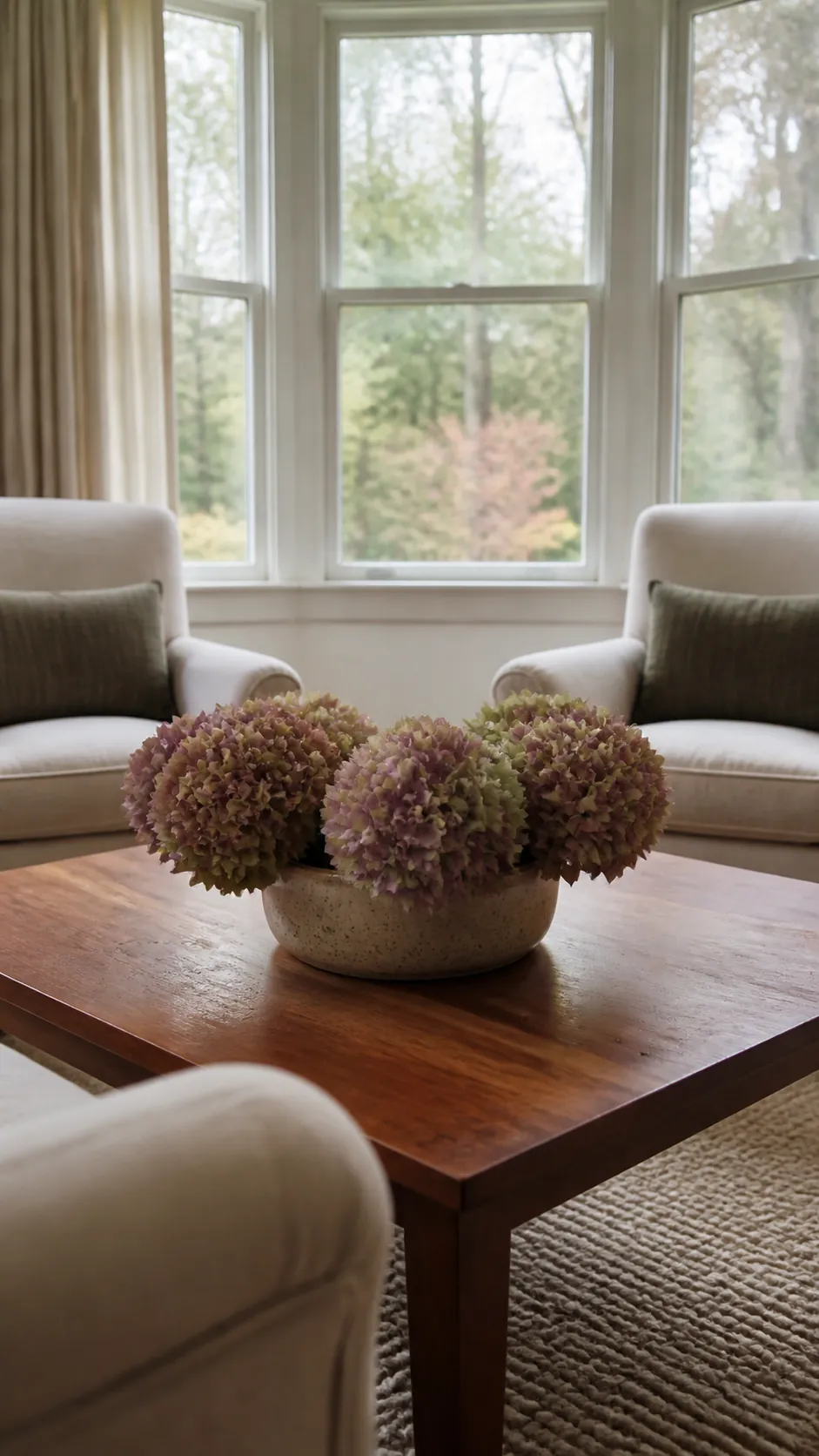 Dried hydrangeas in a stoneware vase on a coffee table