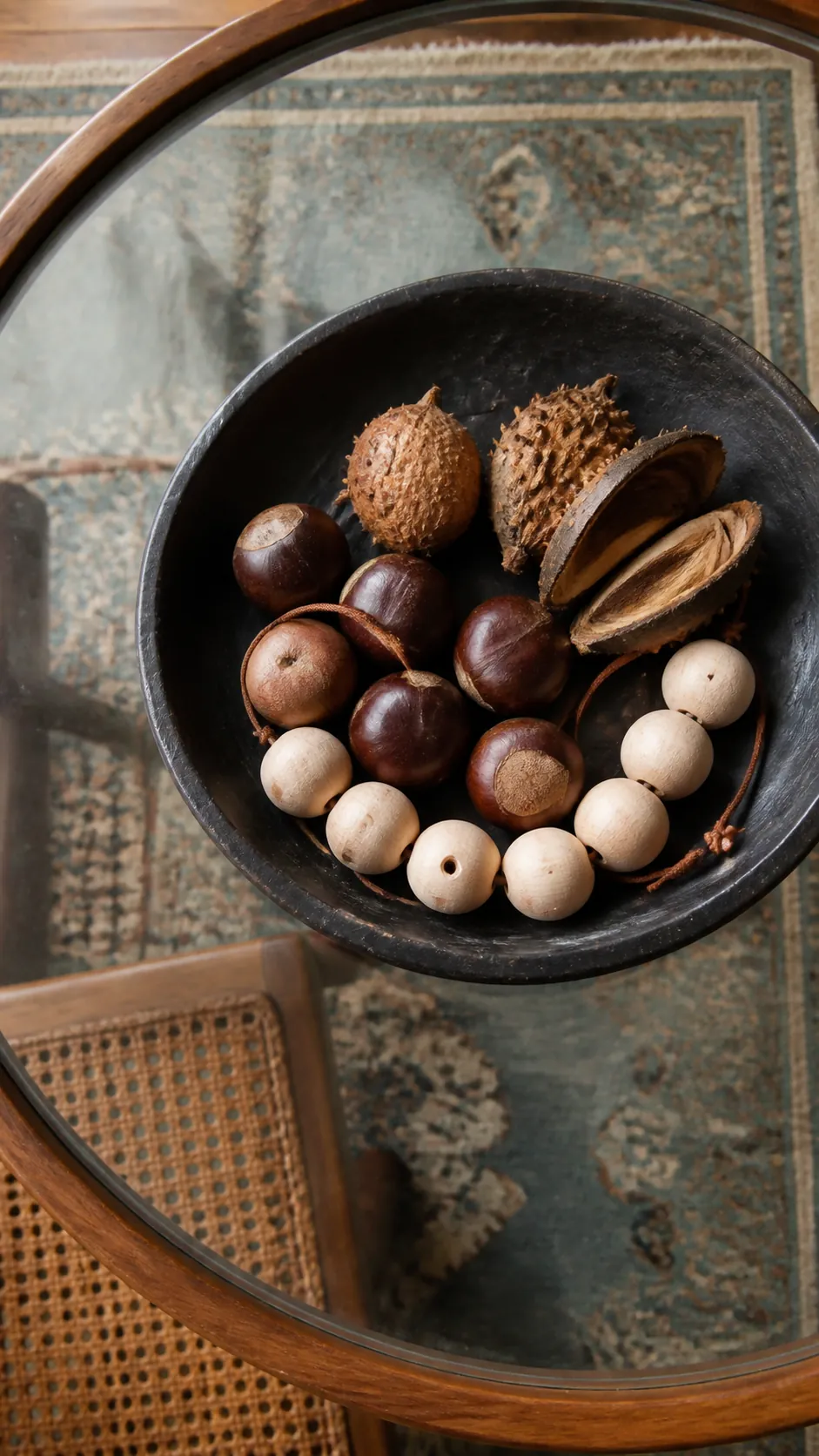 Wood beads arranged with autumn seed pods in a shallow bowl