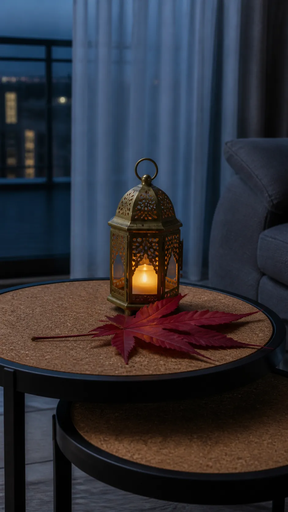 Compact brass lantern beside a red maple sprig