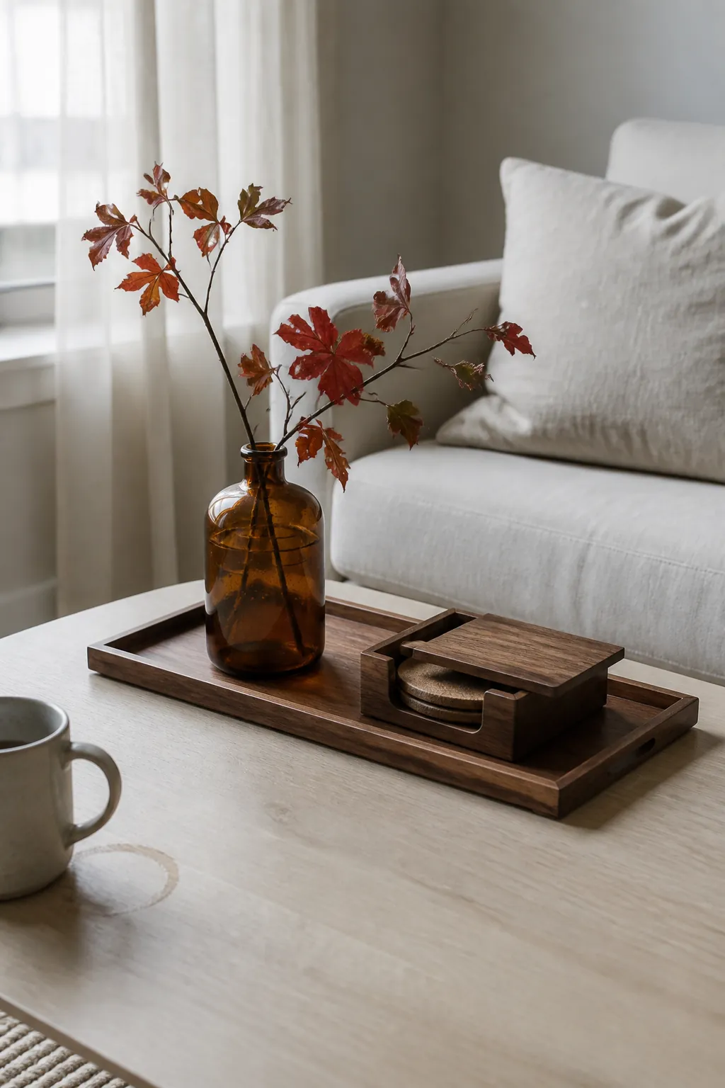 Amber bottle and autumn branches on a walnut tray