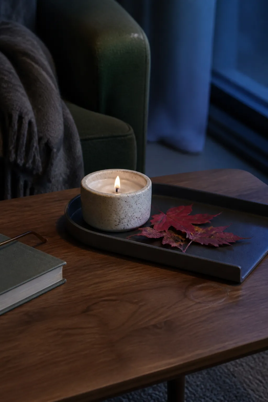 Stone candle and red maple leaves on an autumn tray