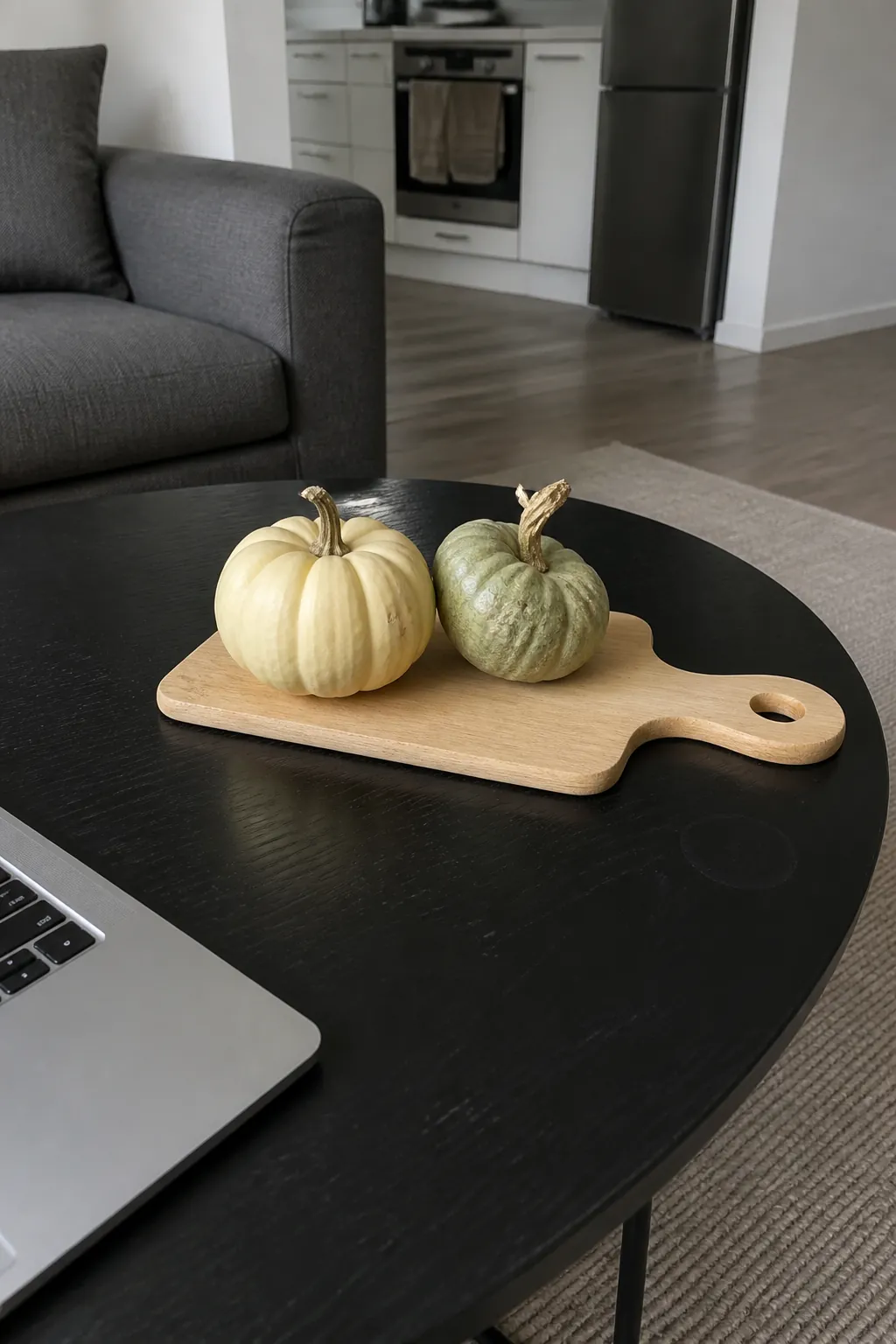 Two mini pumpkins on a small bread board for fall coffee table styling