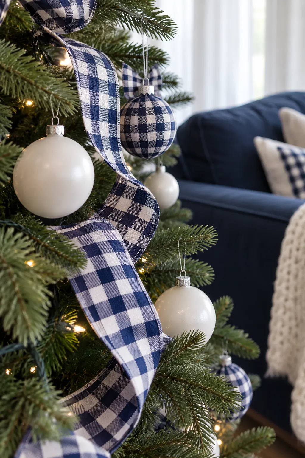 White and Navy Gingham Christmas tree ornaments beside a navy sofa