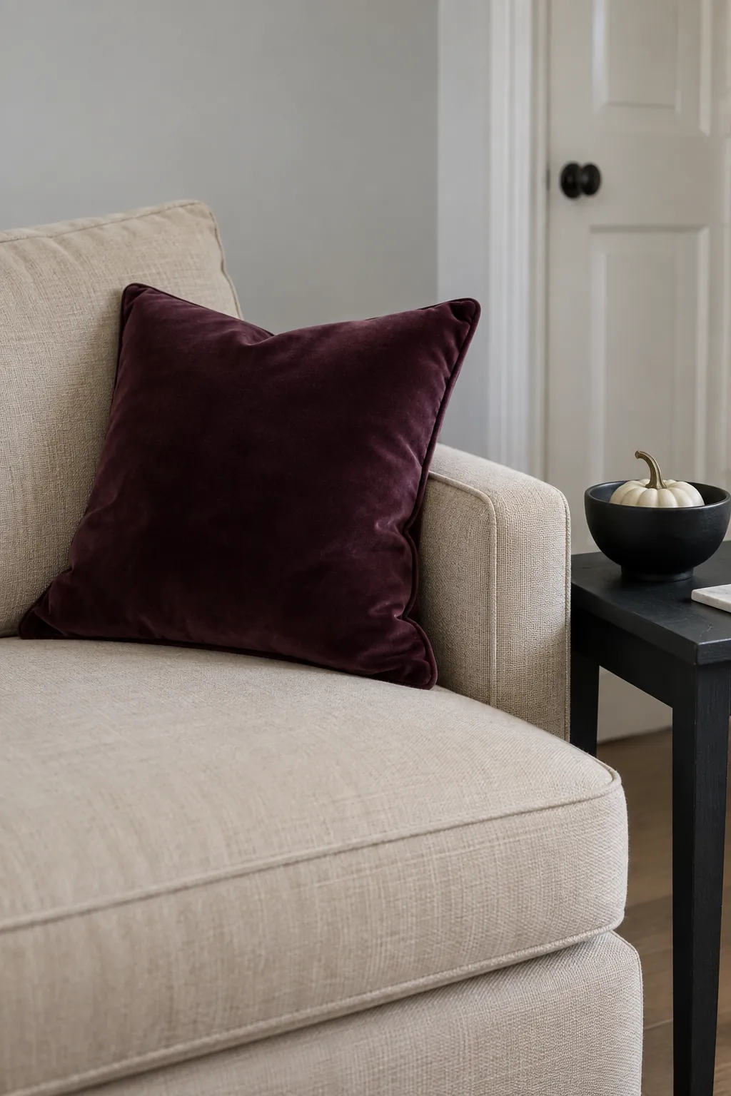 Plum cushion and black accent bowl in an existing neutral room