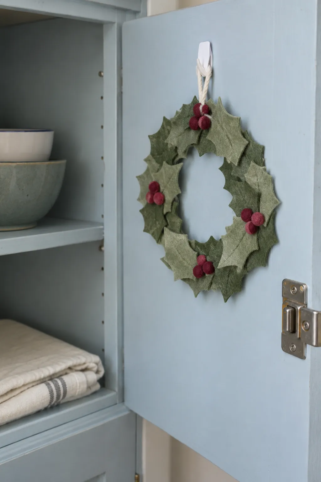 A compact felt wreath in a small apartment Christmas display