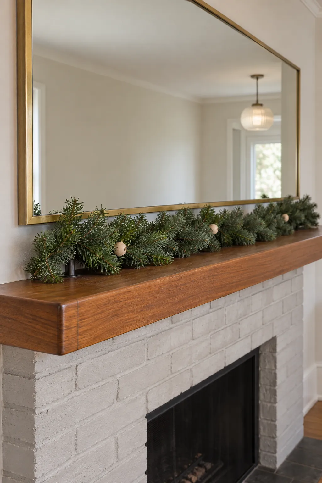 A Garland That Stops at the Shelf Christmas mantel arrangement beneath a large mirror