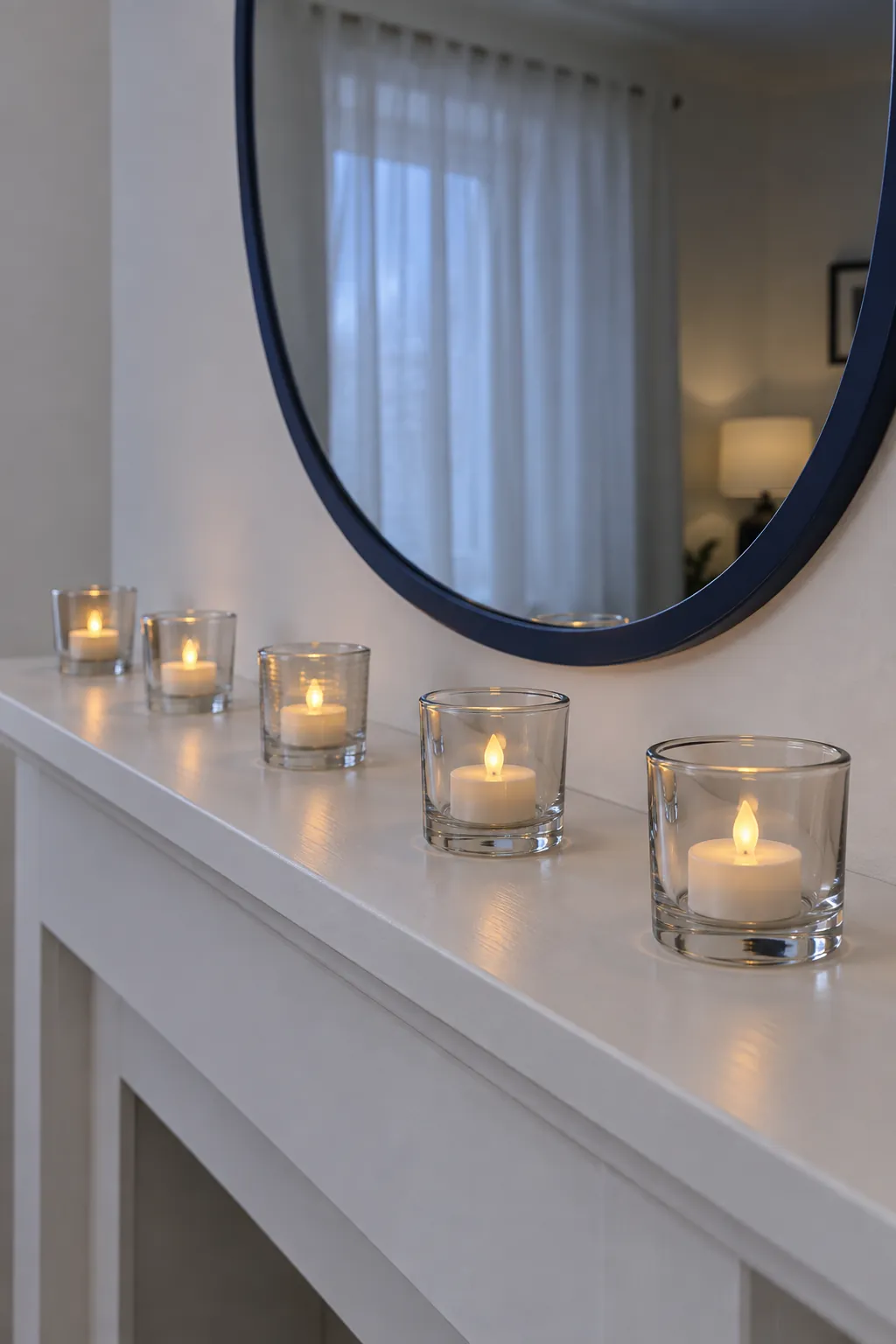 A Line of Small Glass Votives Christmas mantel arrangement beneath a large mirror