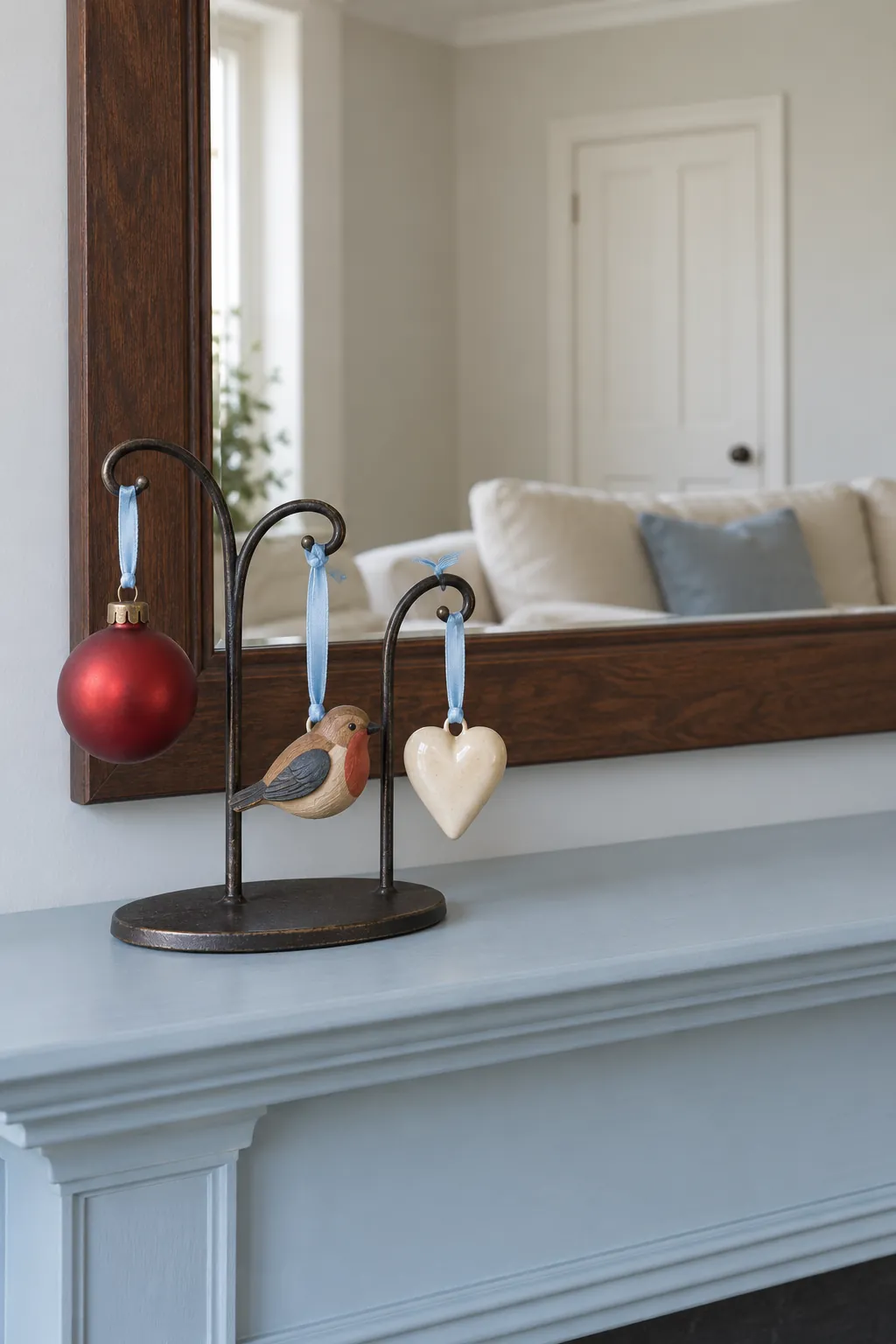 Personal Ornaments in a Small Display Stand Christmas mantel arrangement beneath a large mirror