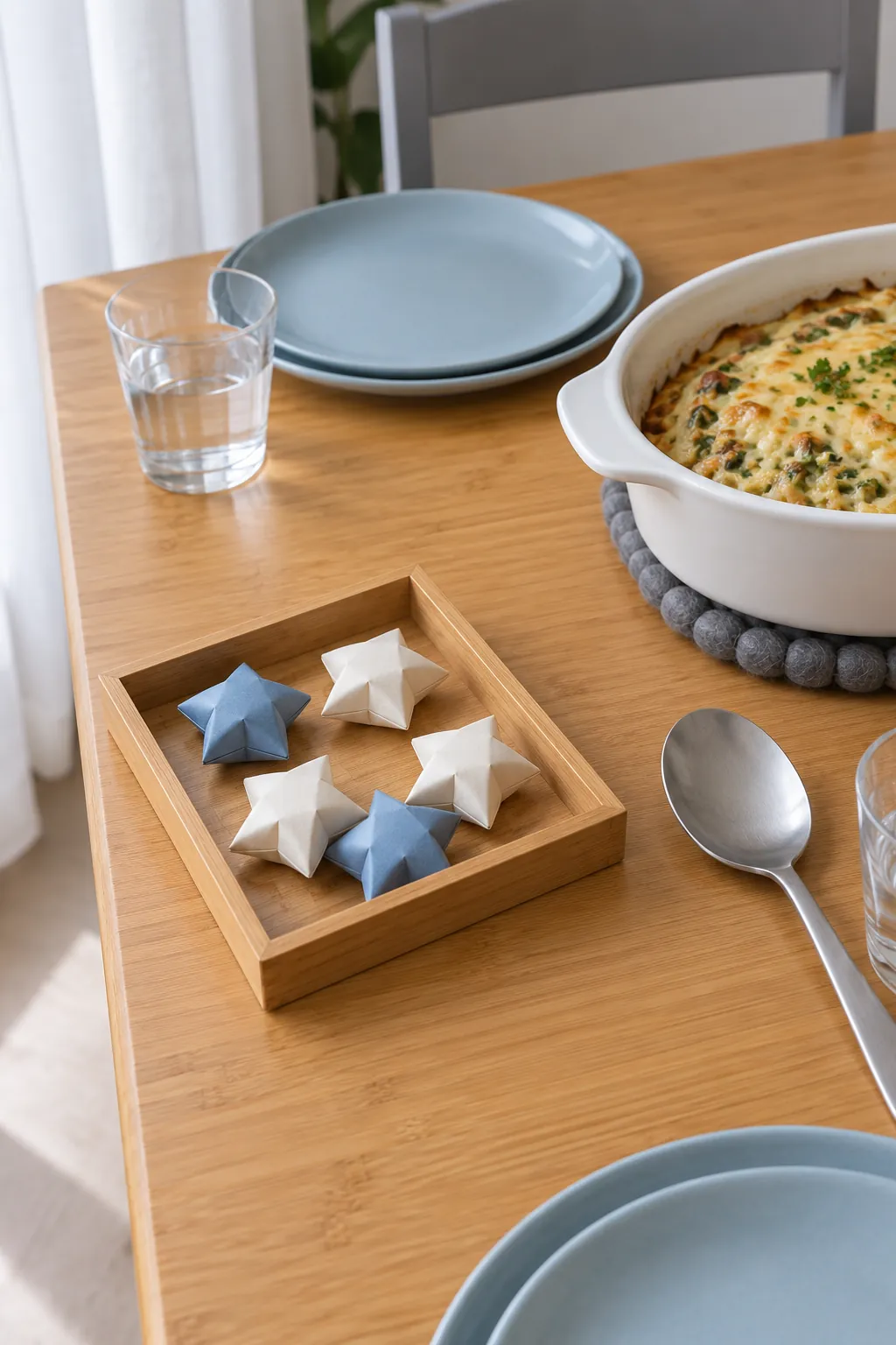Small folded paper stars contained in a low tray away from serving dishes