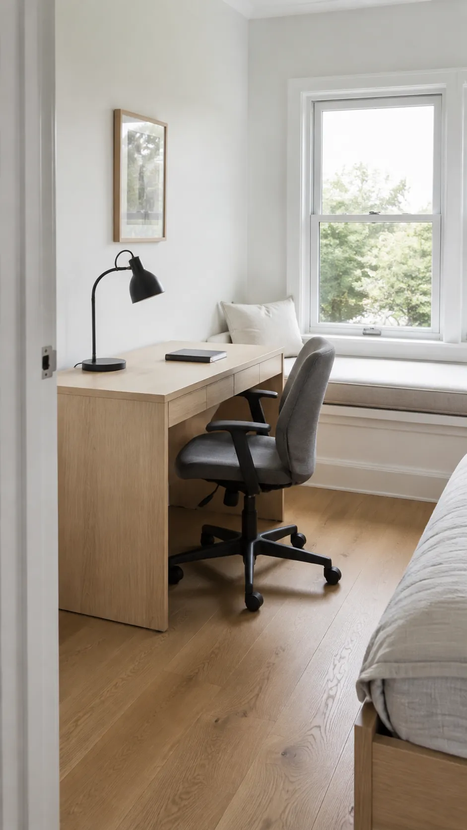 Bedroom window seat beside a comfortable study desk and chair.