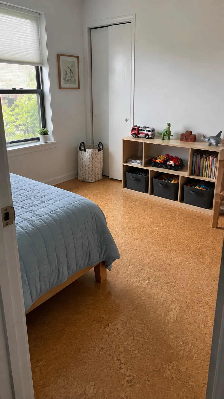 Organized child bedroom with low shelves and clear floor space