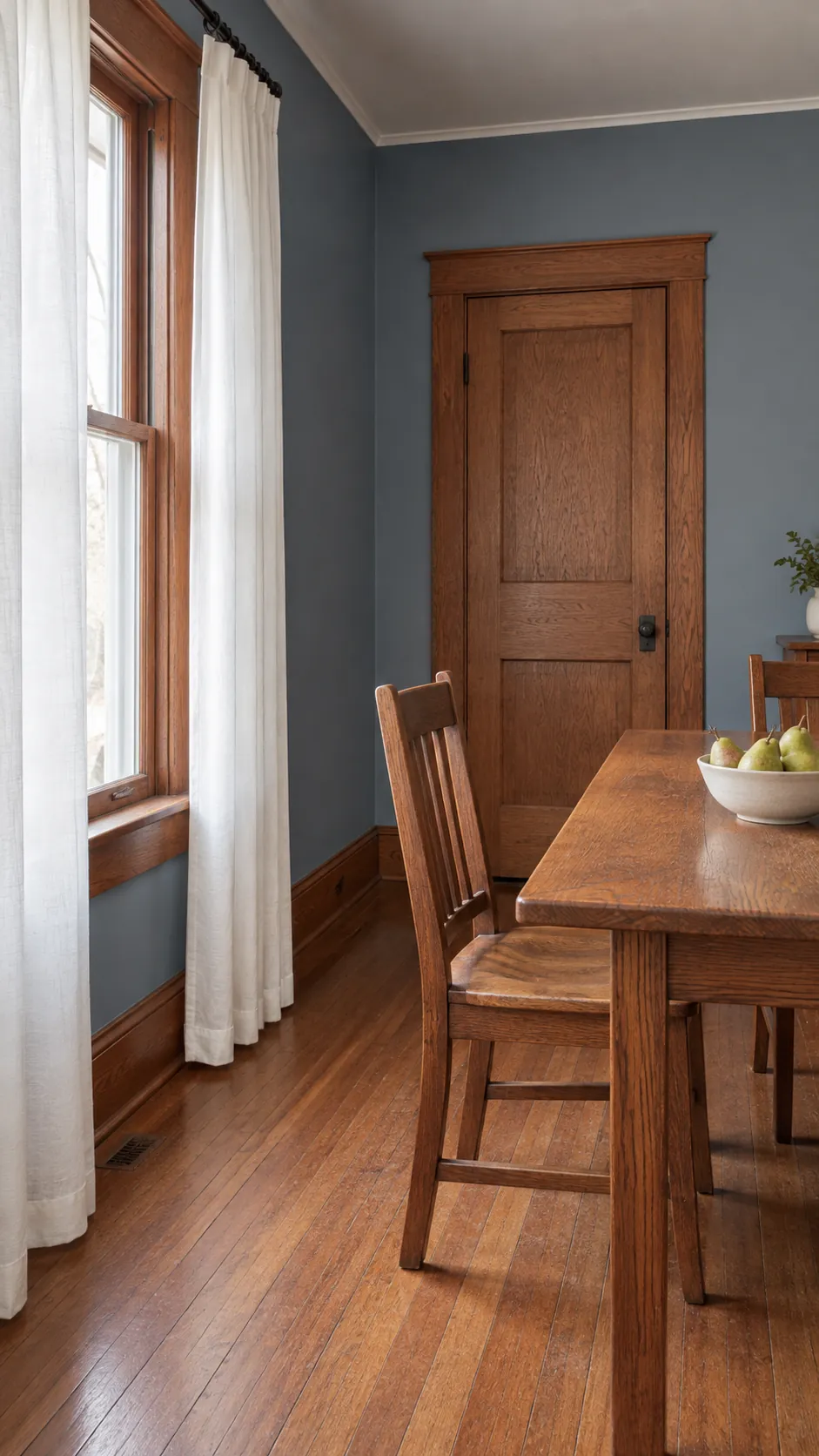 Pewter blue dining room with white curtains and original reddish oak trim