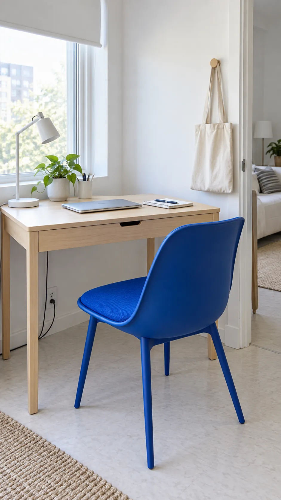 White rental work corner with cobalt chair and pale birch desk