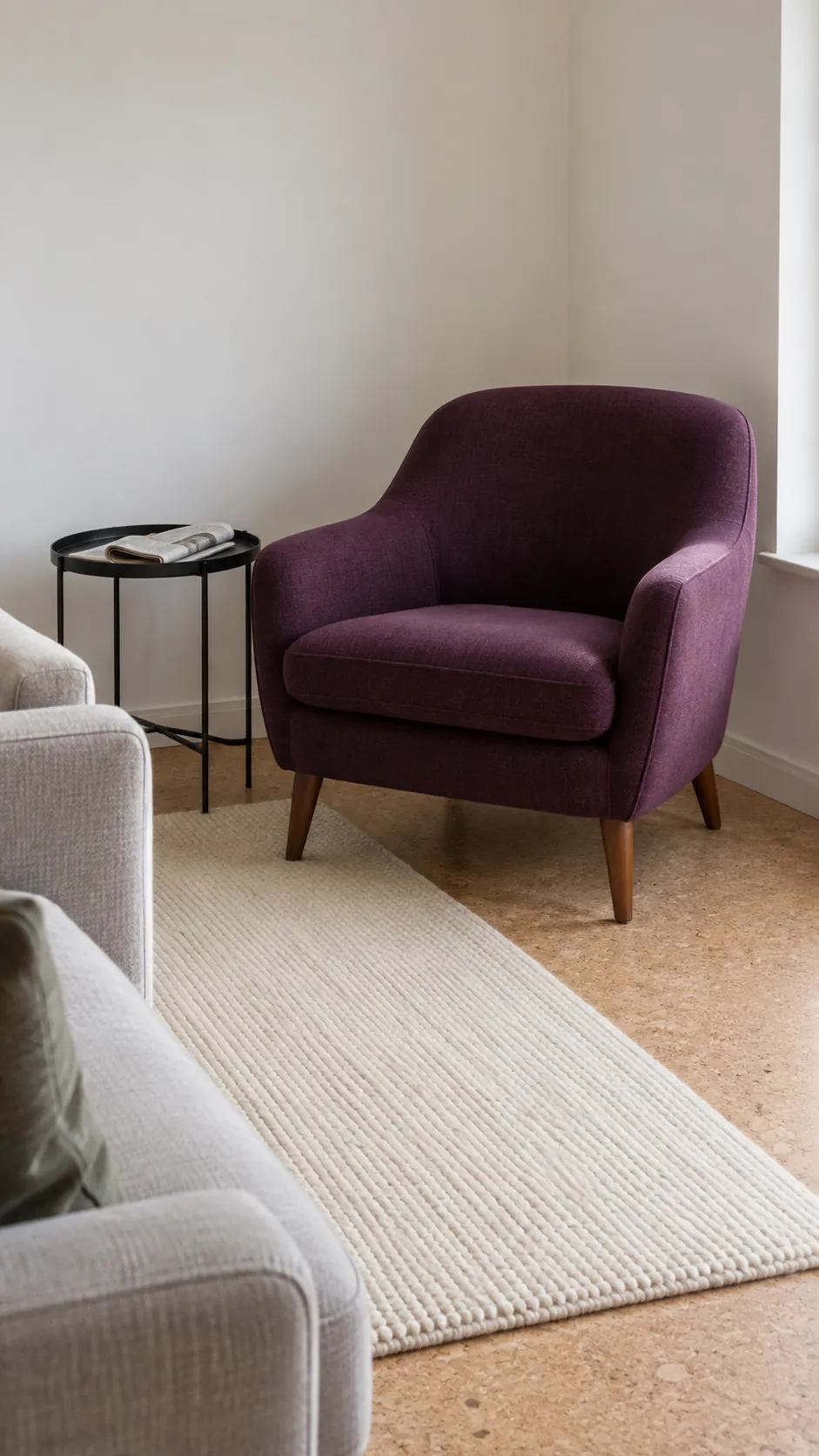 One aubergine armchair with neutral seating and a pale cork floor